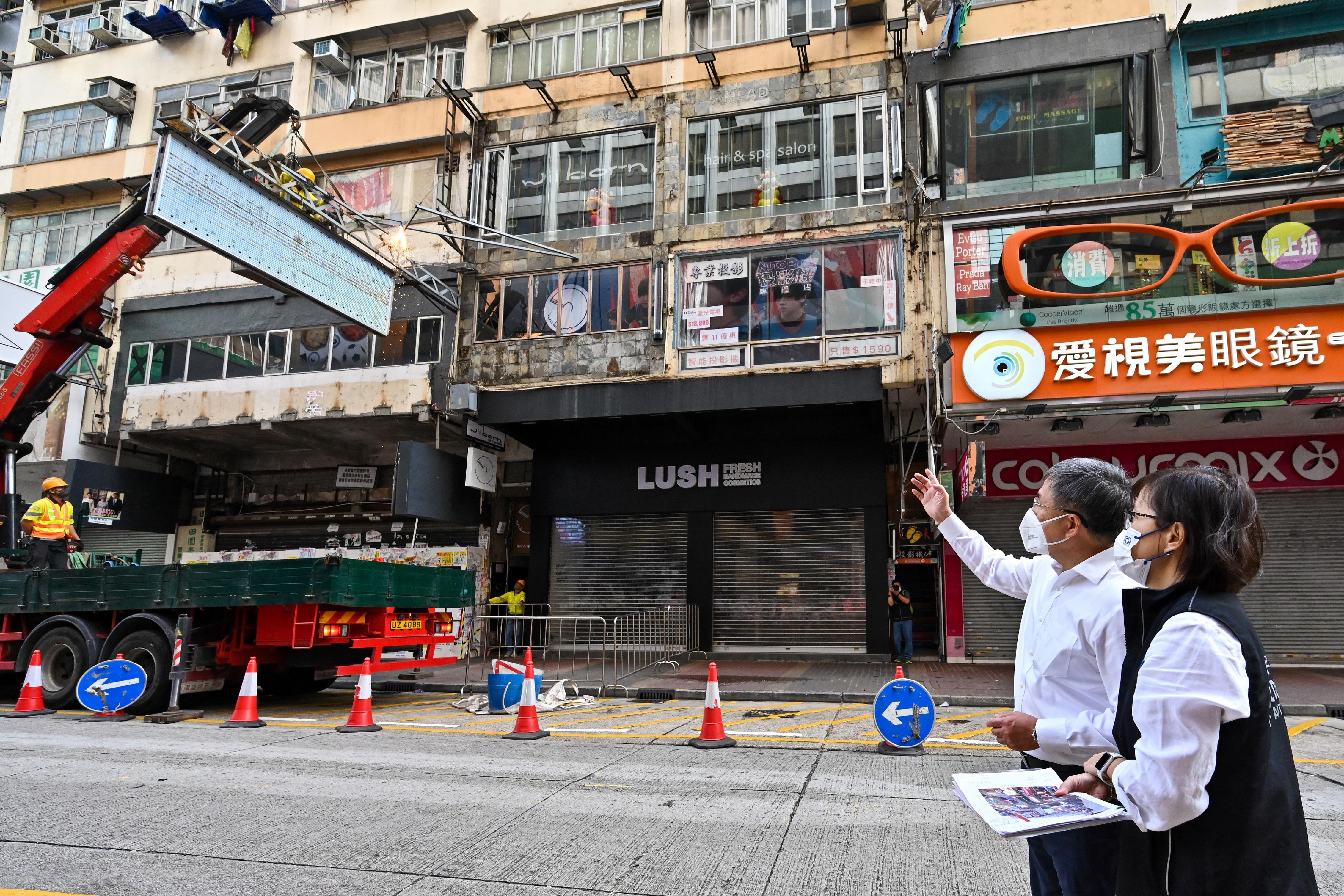 The Deputy Chief Secretary for Administration, Mr Cheuk Wing-hing (left), views signboard removal works at Sai Yeung Choi Street South in Mong Kok this morning (November 15). Next to Mr Cheuk is the Director of Buildings, Ms Clarice Yu (right).