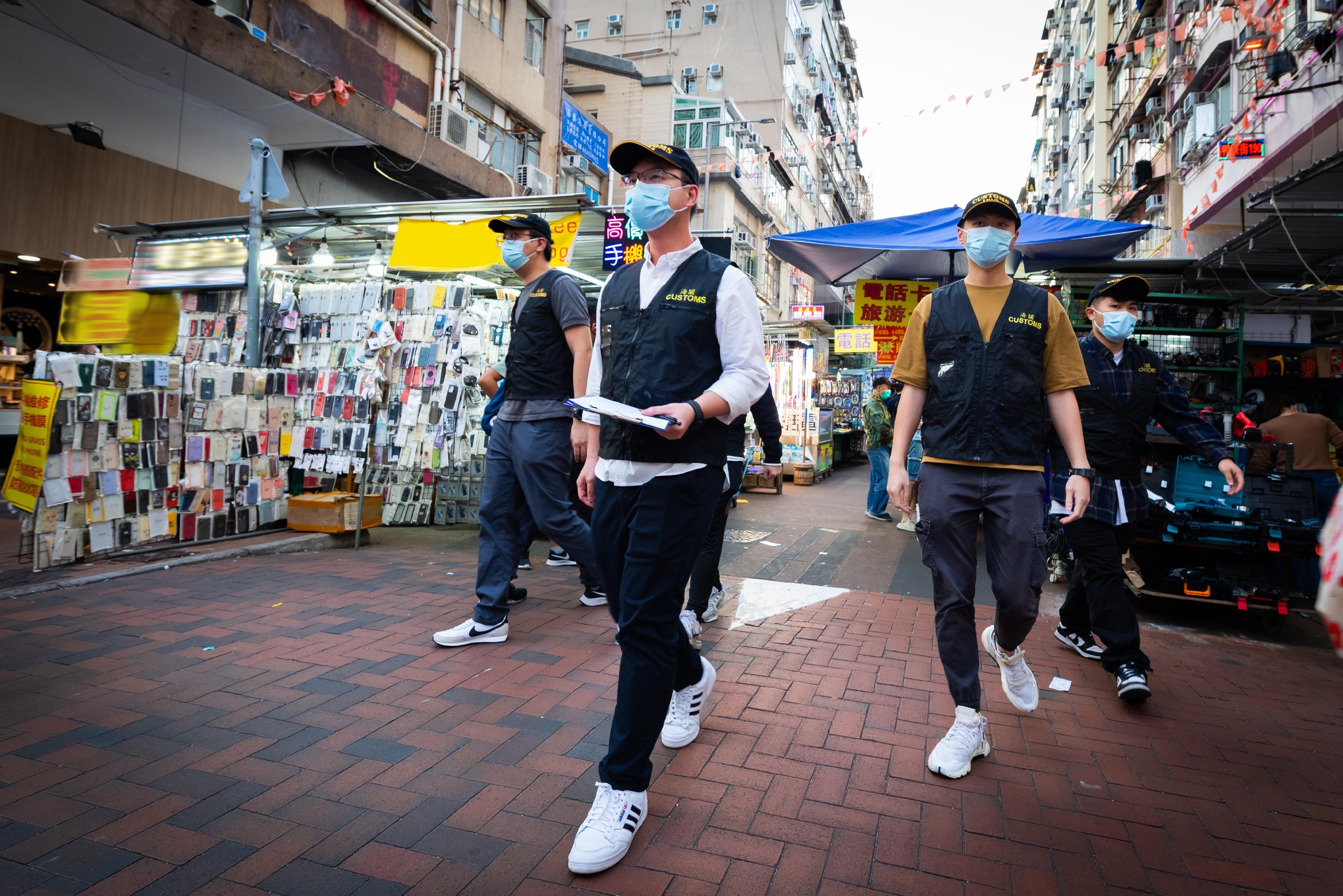 With the 2022 FIFA World Cup matches being held, Hong Kong Customs has maintained close co-operation with copyright owners and trademark owners and has stepped up patrols and enforcement on all fronts, with a view to combating criminals taking the opportunity to conduct infringement activities related to the World Cup during the period. Photo shows Customs officers conducting a spot check in the market.