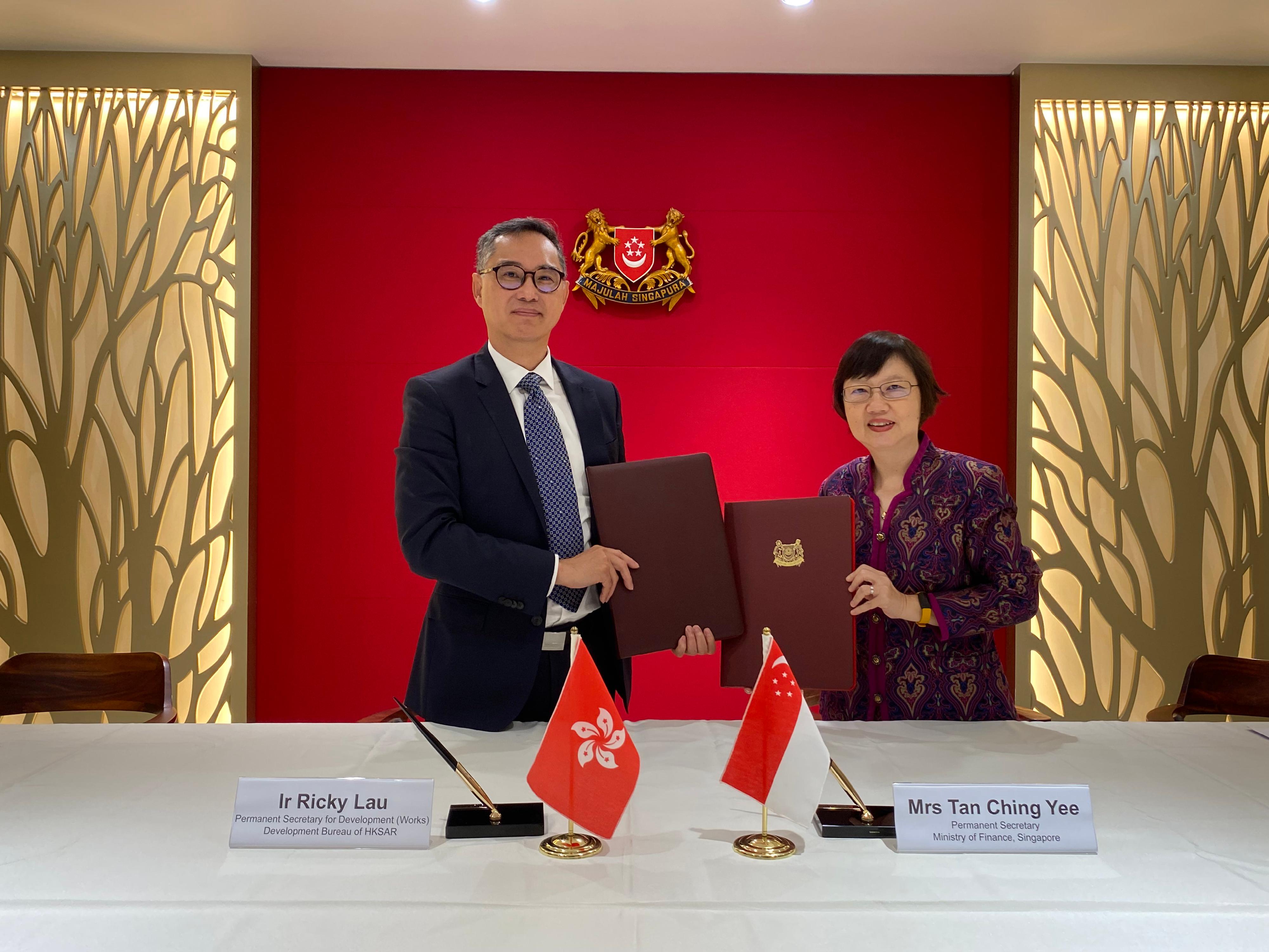 The Permanent Secretary for Development (Works), Mr Ricky Lau (left), and the Permanent Secretary of the Ministry of Finance of Singapore, Mrs Tan Ching Yee (right), signed a Memorandum of Understanding in Singapore today (December 1) to enhance expertise and experience exchanges in infrastructure project management and delivery.