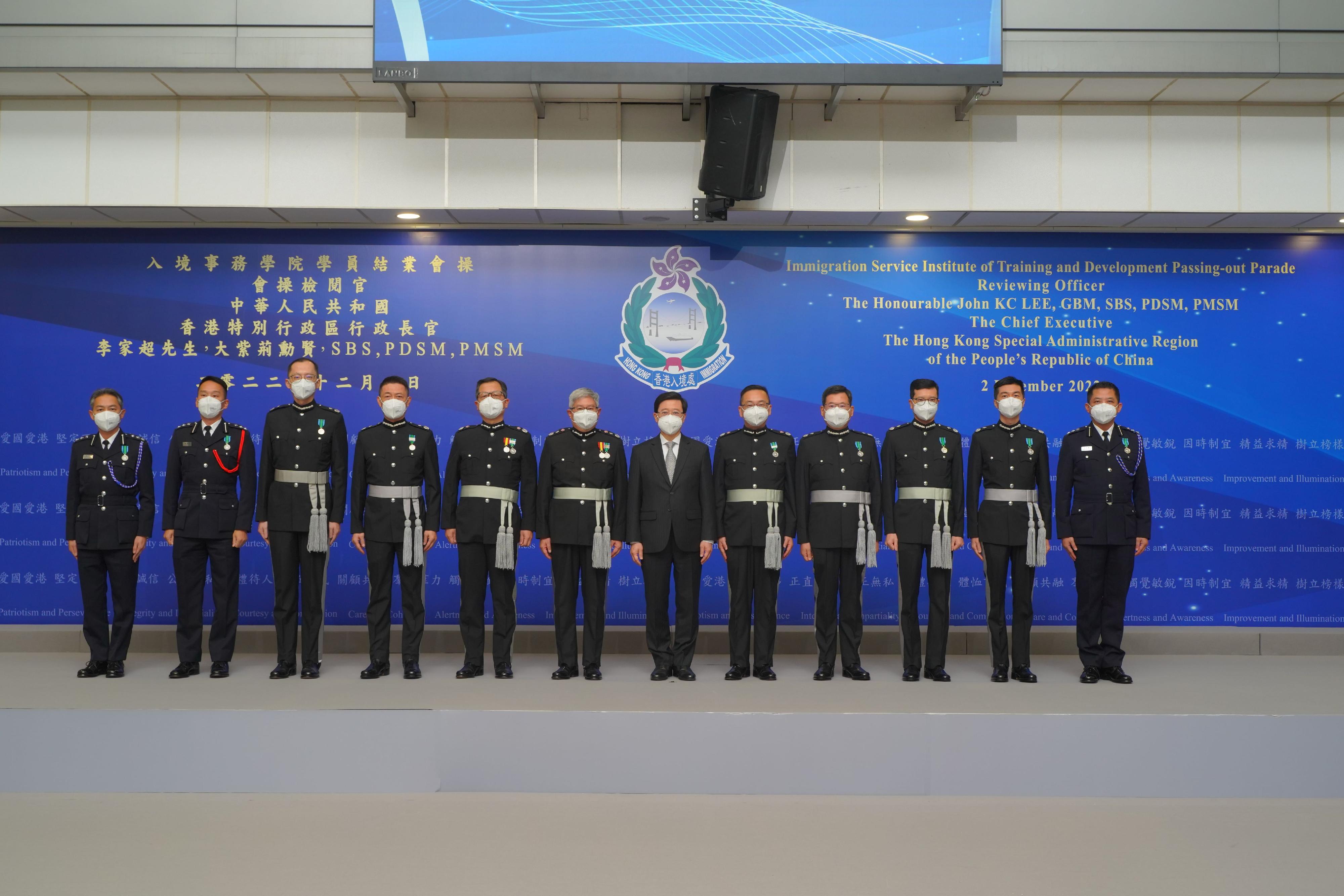 The Immigration Department Passing-out Parade was held today (December 2). Photo shows the Chief Executive, Mr John Lee (sixth right), taking a photo with directorate officers of the Immigration Department after the parade.