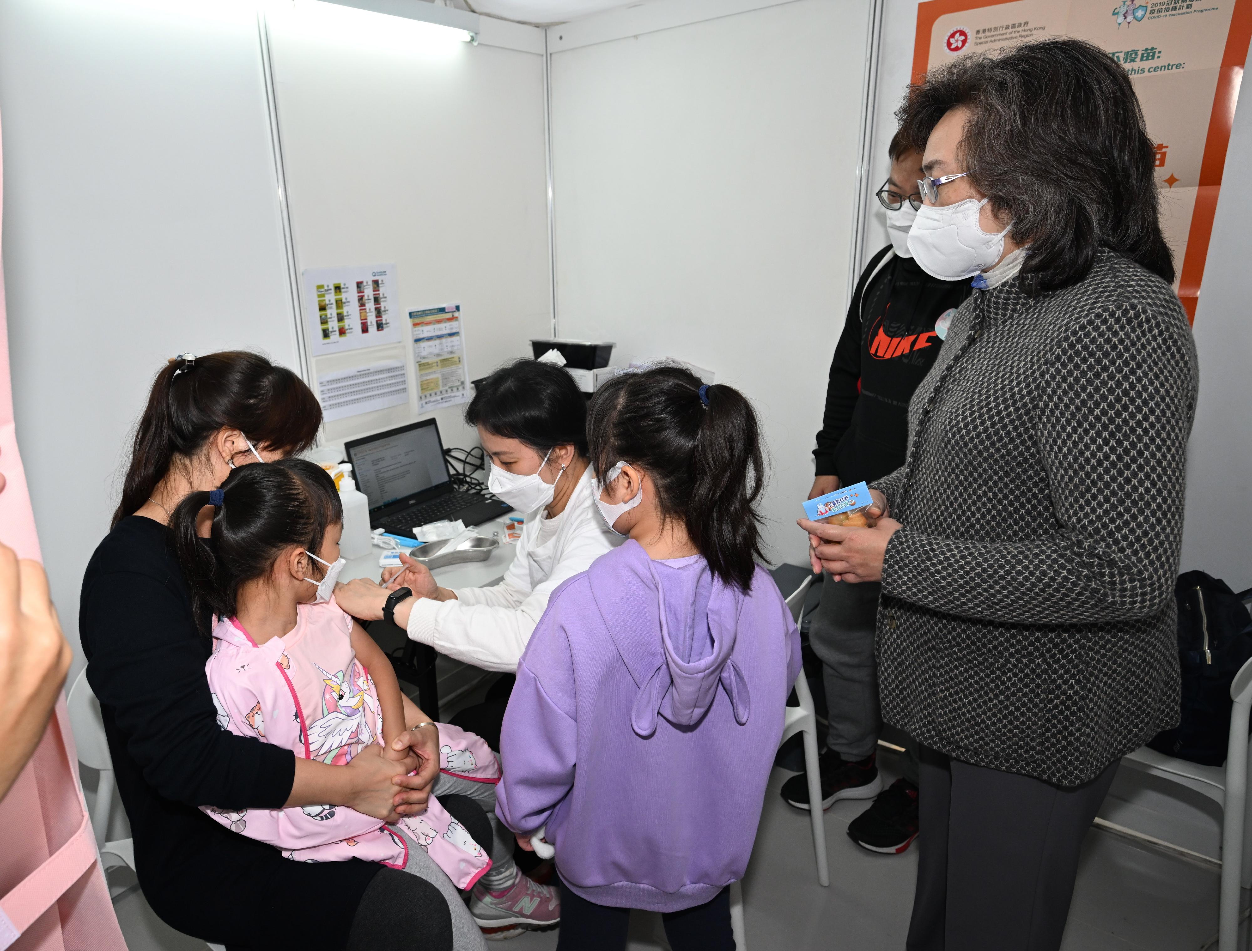 The Secretary for the Civil Service, Mrs Ingrid Yeung, attended "Children with jabs, parents with ease" parent-child activities held by the Government at D·PARK in Tsuen Wan today (December 3) to promote COVID-19 vaccination of children. A mobile vaccination station was set up at the venue providing vaccination service of five kinds of COVID-19 vaccine (the Sinvoac vaccine, the BioNTech bivalent vaccine, the BioNTech ancestral strain vaccine, and the paediatric and toddler formulations of the BioNTech vaccine) for members of the public of different ages to receive on site. Mrs Yeung (first right) is pictured with a child who is receiving her COVID-19 vaccination.