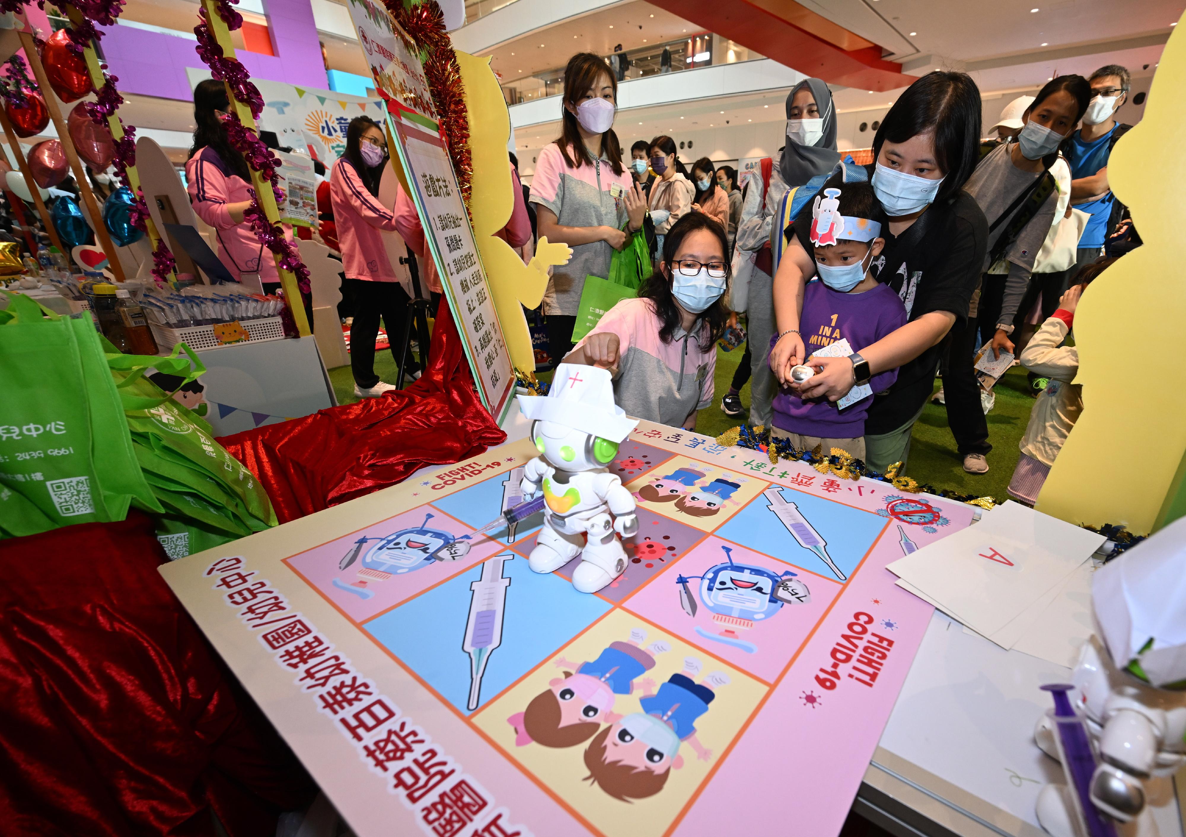 The Government held "Children with jabs, parents with ease" parent-child activities at D·PARK in Tsuen Wan today (December 3) to promote COVID-19 vaccination of children. There were COVID-19 vaccination-themed game booths designed by teachers, students and parents from a number of kindergartens for the public to learn together with their families more about the importance of COVID-19 vaccination through the games. Photo shows the booth game designed by the Yan Chai Hospital Choi Pat Tai Kindergarten/Child Care Centre which won the championship of the most creative booth game.