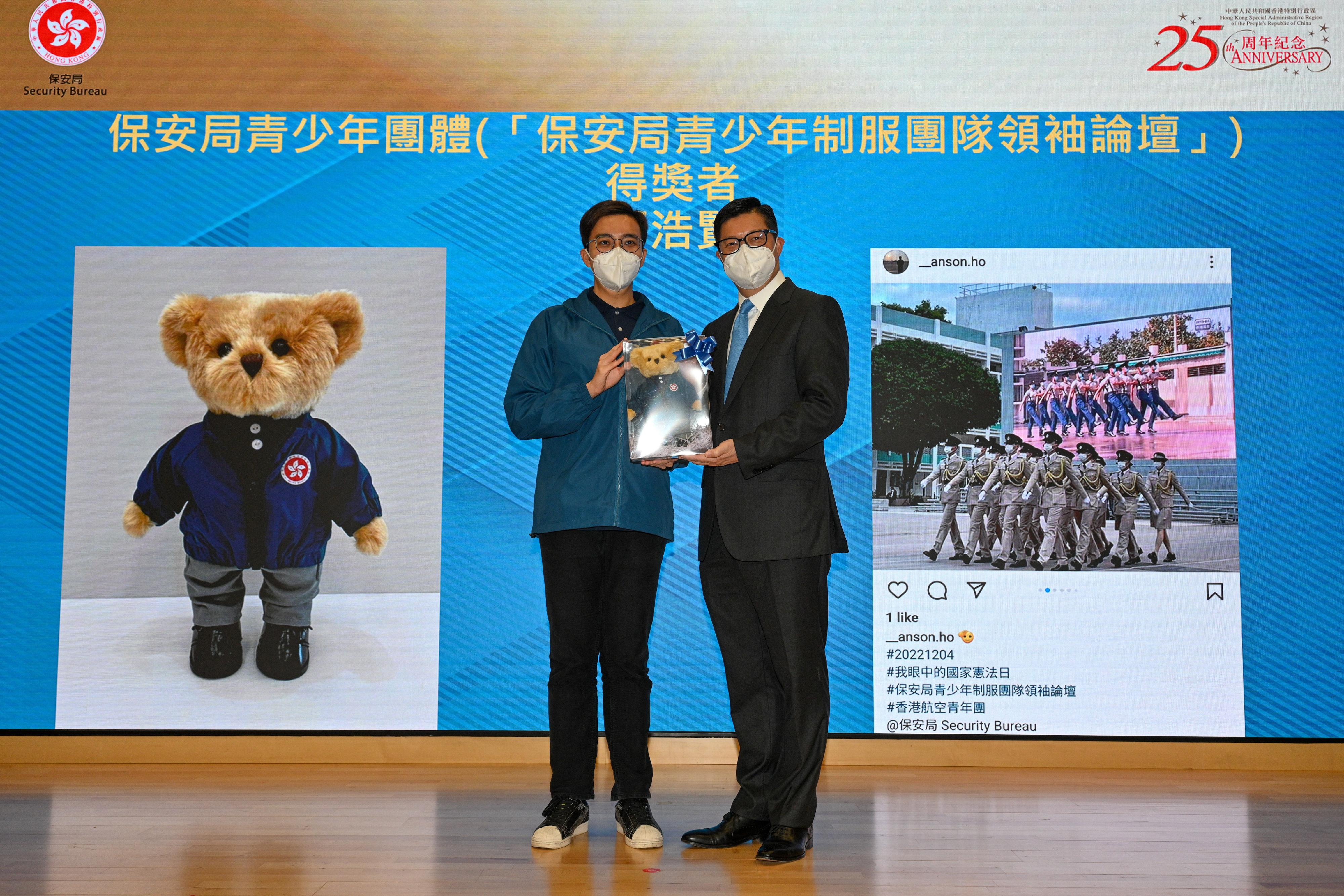 The Security Bureau held the Flag Raising Ceremony to Commemorate 40th Anniversary of Constitution today (December 4). Photo shows the Secretary for Security, Mr Tang Ping-keung (right), presenting a prize to an awardee of "Constitution Day in my eye" photo competition.