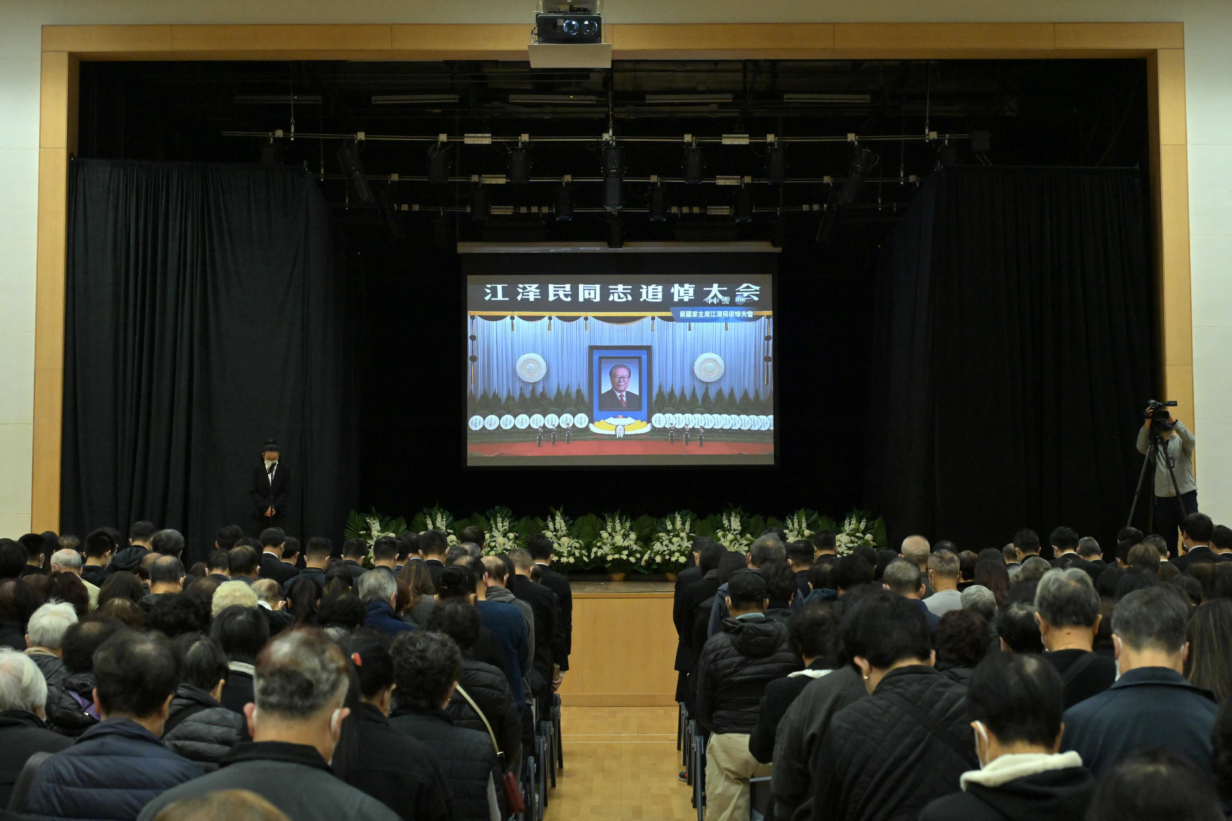 The memorial service for Former President of the People's Republic of China, Mr Jiang Zemin, was held solemnly at the Great Hall of the People in Beijing at 10am today (December 6). The 18 District Offices made arrangements to enable members of the public to watch the live broadcast of the memorial service and observe the mourning in silence at designated locations across the territory. Photo shows the live broadcast of the service at the Sau Mau Ping Community Hall.
