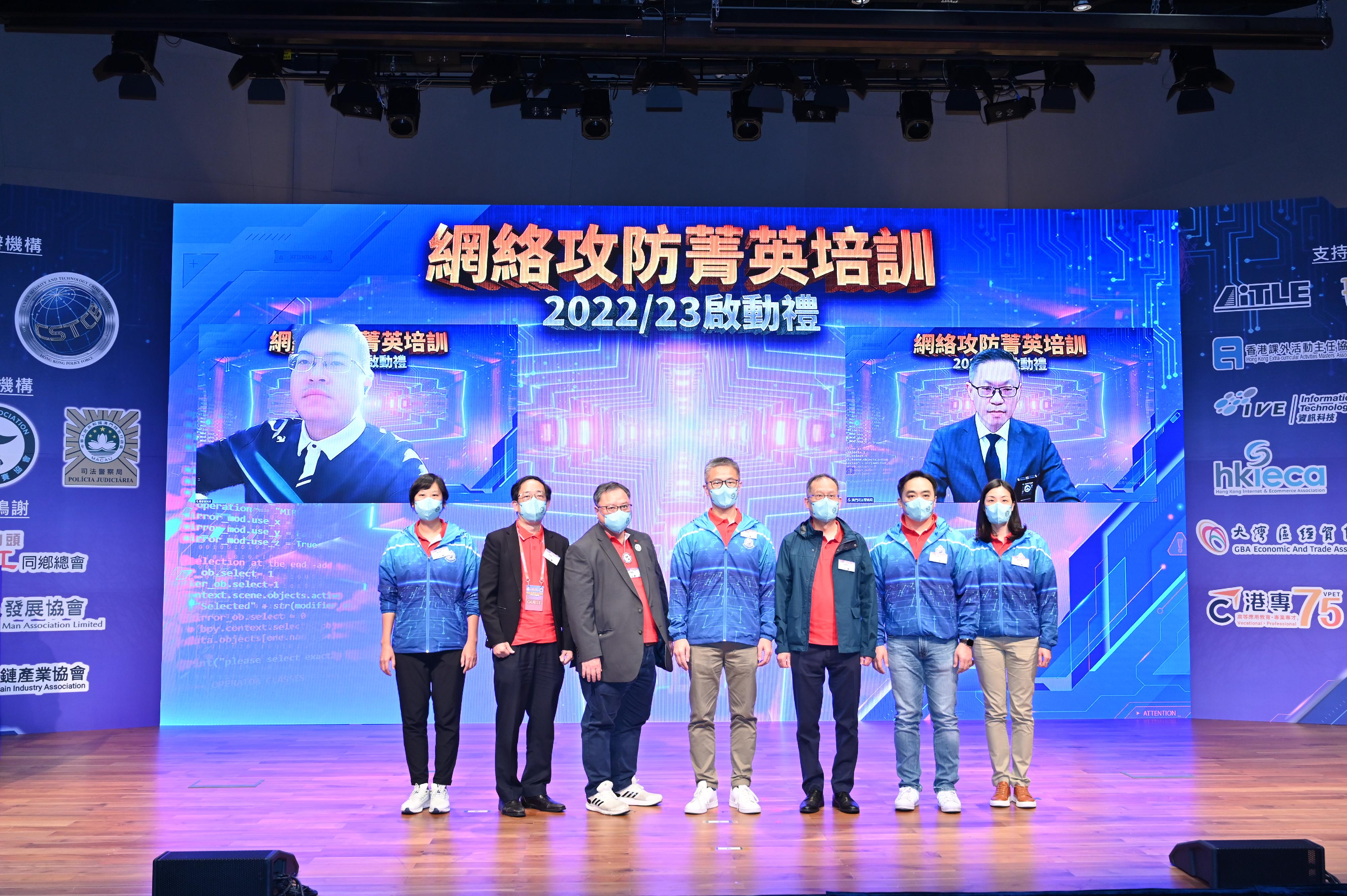 The Commissioner of Police, Mr Siu Chak-yee (centre); the President of the Hong Kong Metropolitan University, Professor Paul Lam (third right); the Chairman of Hong Kong Capture the Flag Association, Mr Frankie Leung (third left); the Chairman of Association of I.T. Leaders in Education, Mr Albert Wong (second left); the Vice President of QI-ANXIN Technology Group, Mr Liu Jin (left on screen); the Director of the Judiciary Police of the Macao Special Administrative Region Government, Mr Sit Chong-meng (right on screen); the Deputy Commissioner of Police (Operations), Mr Yuen Yuk-kin (second right); the Assistant Commissioner of Police (Crime), Ms Chung Wing-man (first left); and the Chief Superintendent (Cyber Security and Technology Crime Bureau), Ms Cheng Lai-ki (first right), officiate at the Cyber Attack and Defence Elite Training 2022/23 - Youth Series kick-off ceremony today (December 10).