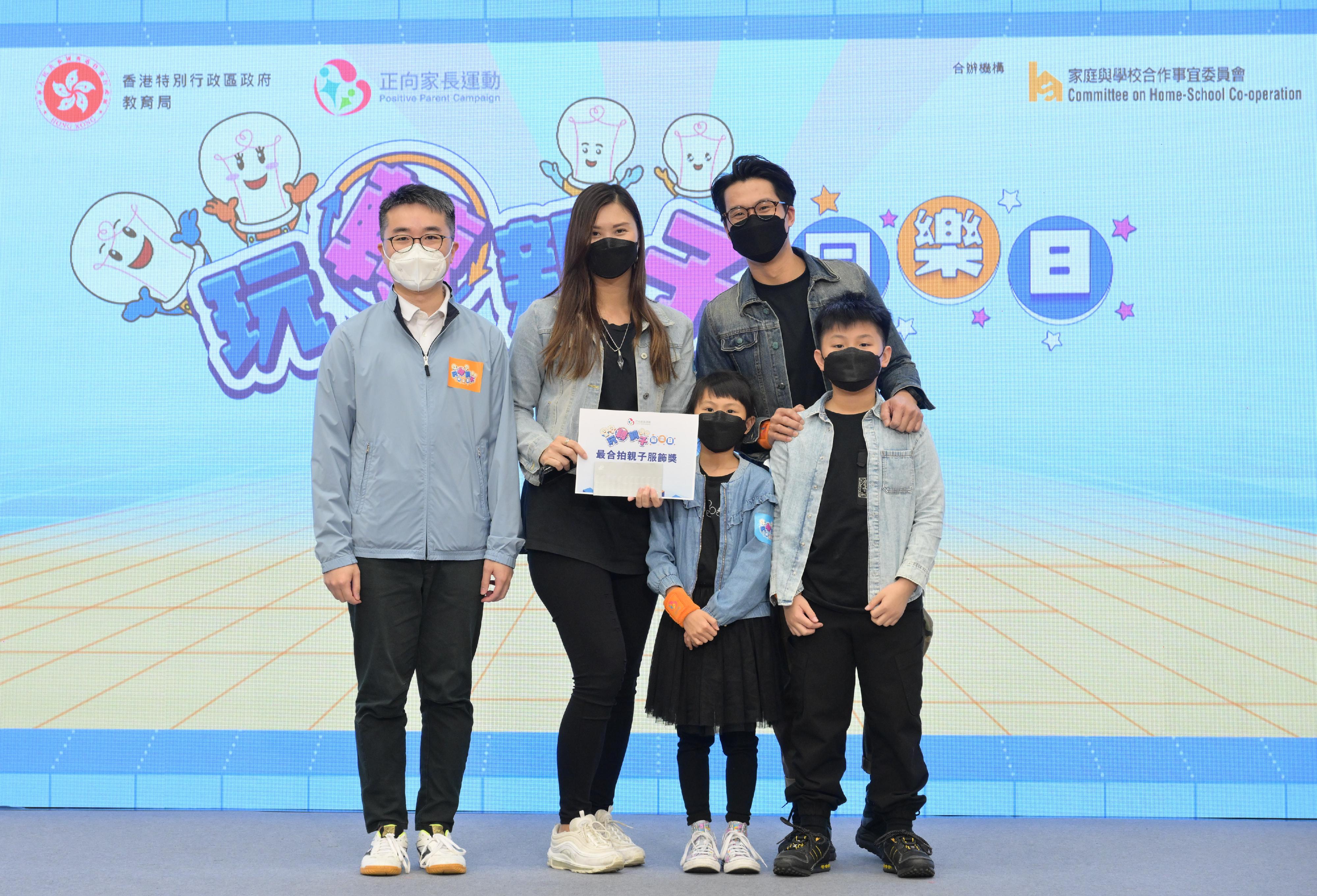 The Under Secretary for Education, Mr Sze Chun-fai (first left), presents the "Most Harmonious Parent-child Outfit Award" to the winners at the Play with Your Children Day today (December 11).