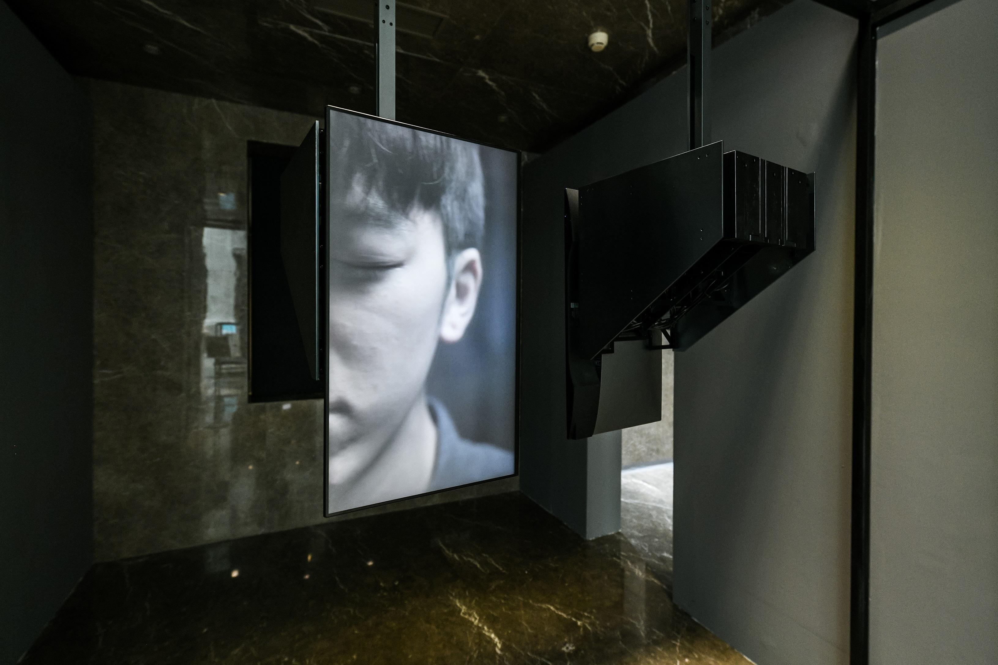The "2022 Hong Kong-Macao Visual Art Biennale" is being held at the Beijing Quanyechang Cultural Arts Centre. Photo shows Hong Kong artist Tung Wing-hong's kinetic video installation "i/i", an installation of two hanging and rotating TV monitors. Each monitor performs its own rotation while playing videos of the artist gazing at his own mirror image, and strangeness is revealed by the long gaze. 