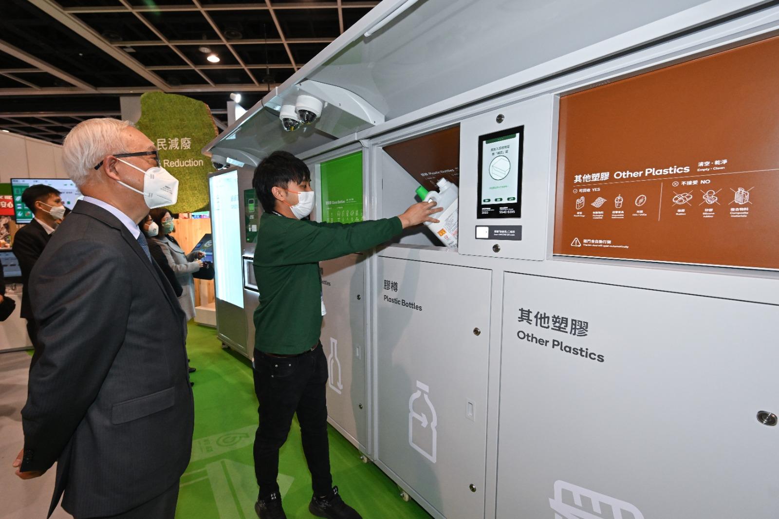 The Secretary for Environment and Ecology, Mr Tse Chin-wan (first left), visits the 17th Eco Expo Asia today (December 14) and is briefed on the operation of the Smart Recycling Systems in the "Waste Reduction" Zone.