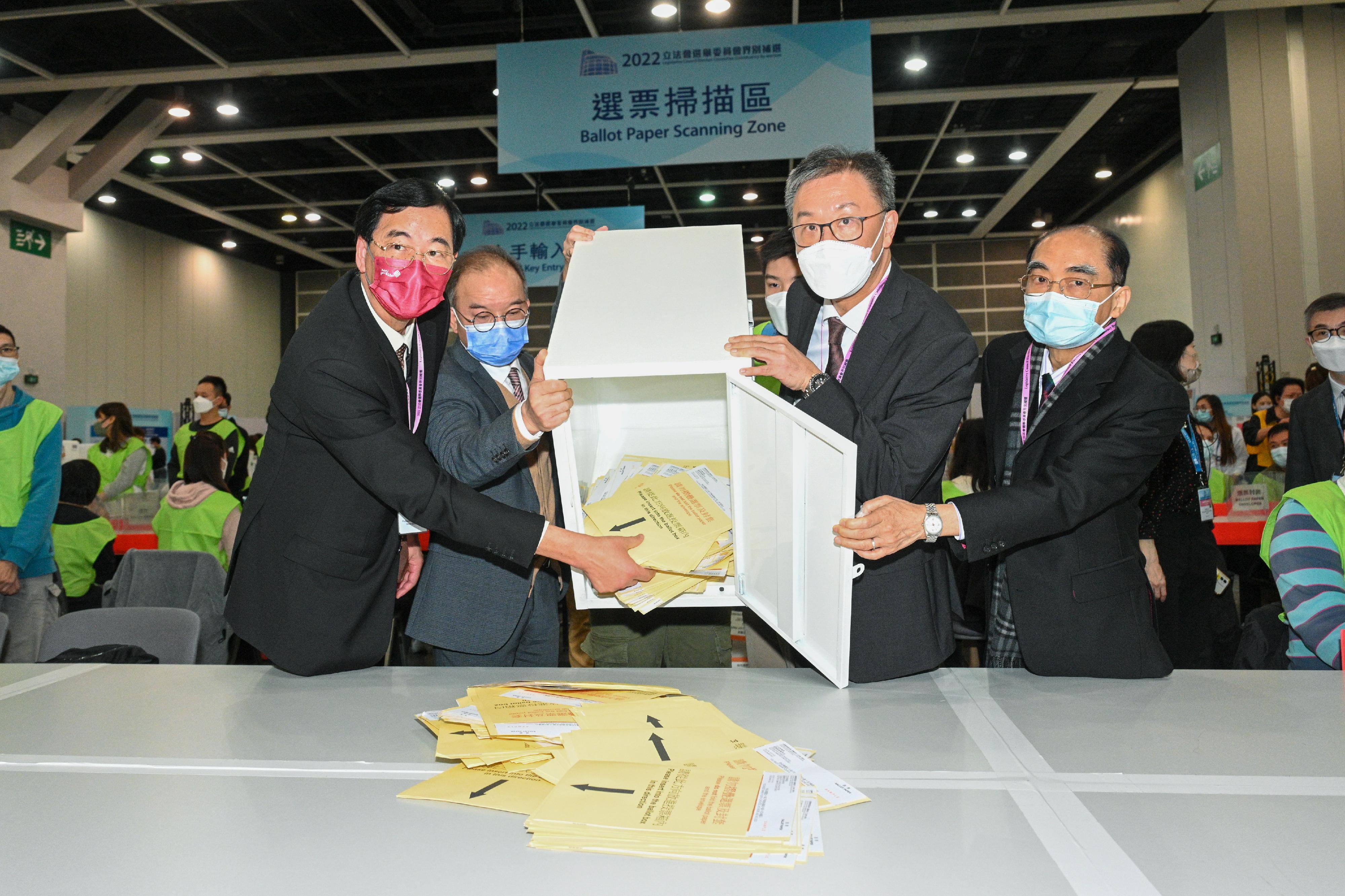 The Chairman of the Electoral Affairs Commission (EAC), Mr Justice David Lok (second right), the Secretary for Constitutional and Mainland Affairs, Mr Erick Tsang Kwok-wai (second left), together with EAC members Mr Arthur Luk, SC (first right), and Professor Daniel Shek (first left), visited the central counting station of the 2022 Legislative Council Election Committee constituency by-election at the Hong Kong Convention and Exhibition Centre today (December 16). Photo shows them in a simulation of emptying a ballot box.