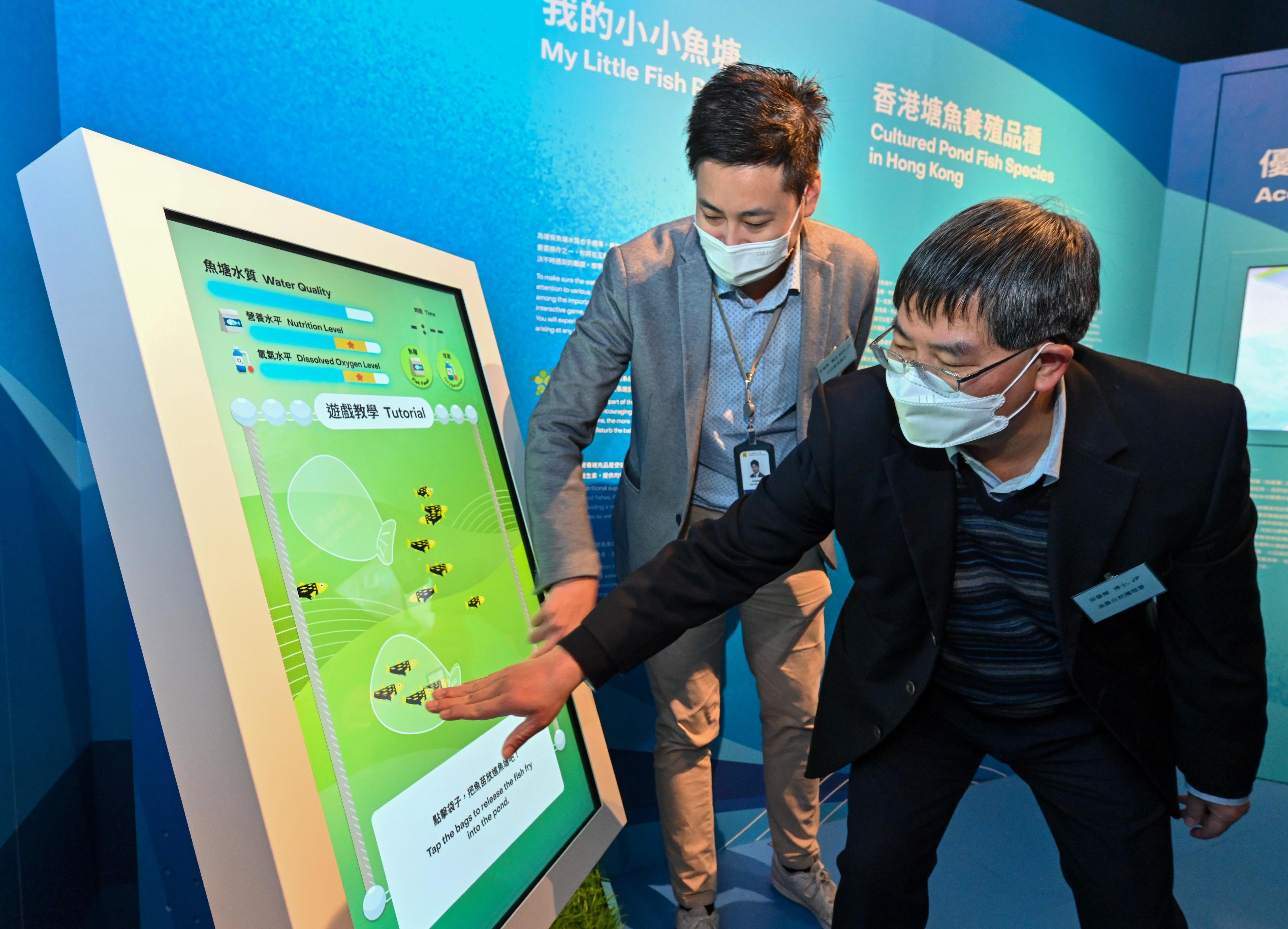 The Fisheries Hall located at the Lions Nature Education Centre at Tsiu Hang, Sai Kung, reopened today (December 16) upon completion of its revamp. Photo shows the Director of Agriculture, Fisheries and Conservation, Dr Leung Siu-fai (right), and Legislative Council Member Mr Steven Ho playing the multimedia interactive game "My Little Fish Pond".