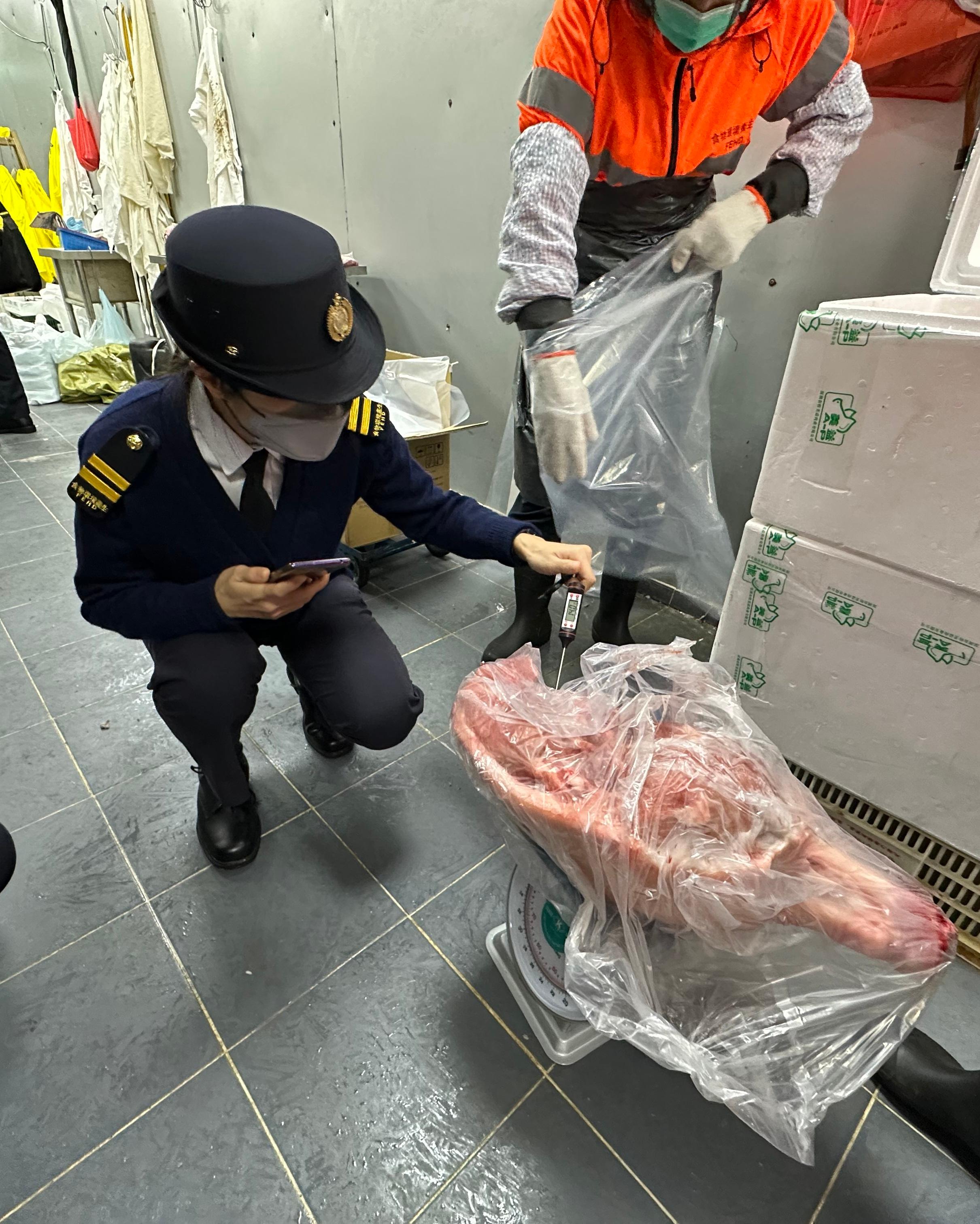 The Food and Environmental Hygiene Department (FEHD) raided a licensed fresh provision shop in Sham Shui Po District suspected of selling chilled meat as fresh meat today (December 16). Photo shows FEHD officer investigating on site.