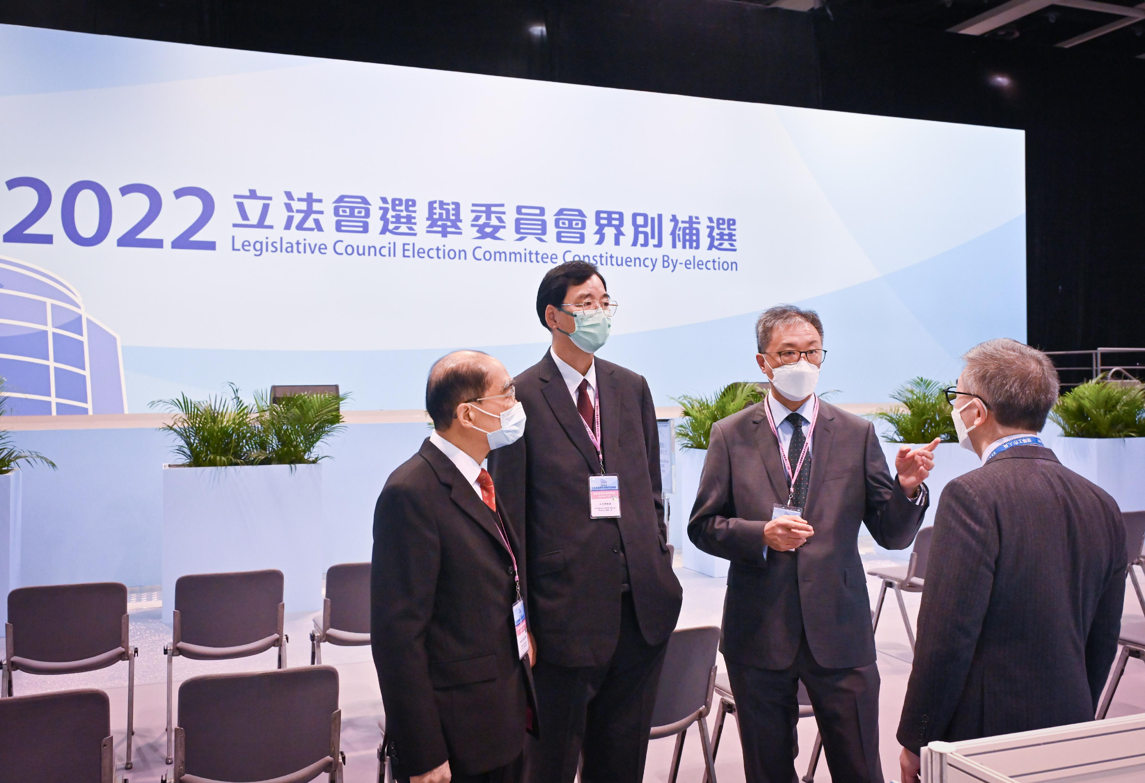 The Chairman of the Electoral Affairs Commission (EAC), Mr Justice David Lok (second right), EAC members Mr Arthur Luk, SC (first left), and Professor Daniel Shek (second left) were briefed by the Chief Electoral Officer of the Registration and Electoral Office, Mr Raymond Wang (first right) during their visit to the central counting station of the 2022 Legislative Council Election Committee constituency by-election at the Hong Kong Convention and Exhibition Centre today (December 17).
