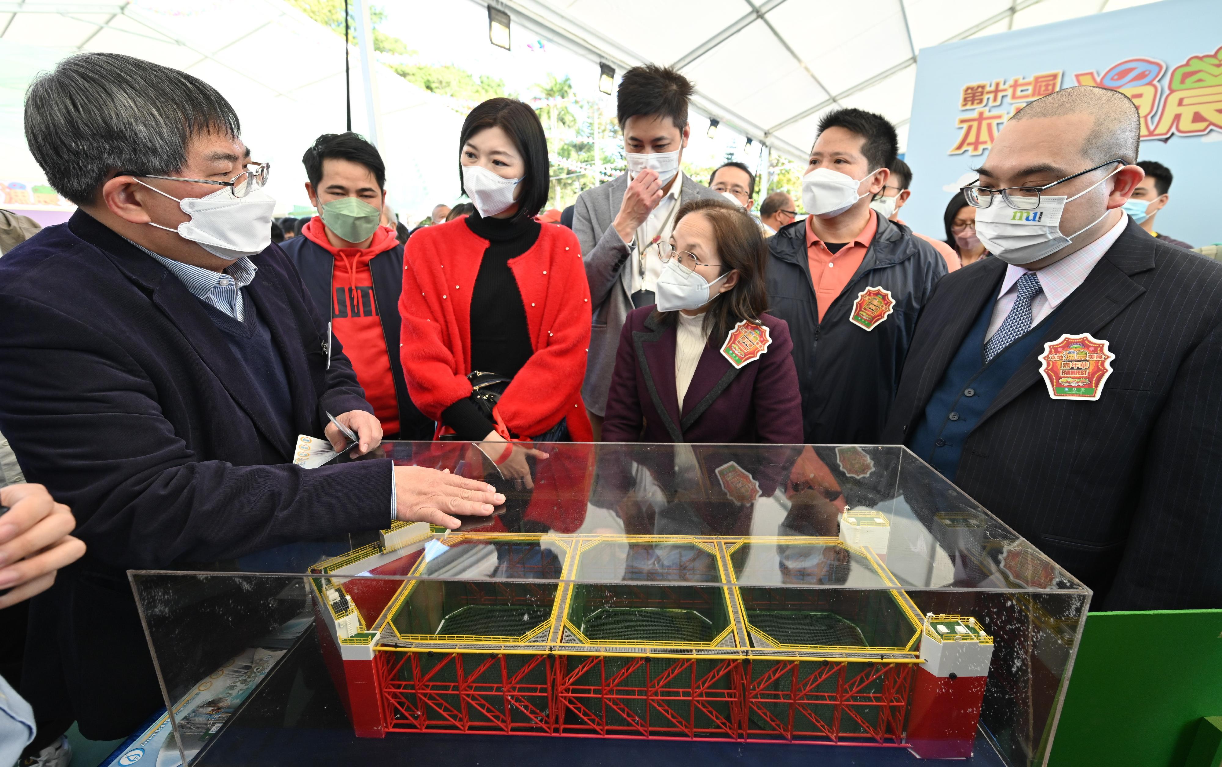 The 17th FarmFest is being held at Fa Hui Park in Mong Kok for three consecutive days between today (December 25) and December 27 to showcase a variety of local agricultural and fisheries products and other goods. Photo shows the Under Secretary for Environment and Ecology, Miss Diane Wong (front row, second right); the Chairman of the Organising Committee of FarmFest, Dr Eric Lau (front row, first right); Legislative Council members Mr Steven Ho (back row, centre) and Ms Yung Hoi-yan (front row, second left); the Director of Agriculture, Fisheries and Conservation, Dr Leung Siu-fai (front row, first left); and other guests viewing a semi-submersible steel truss deep sea cage model exhibited in the fisheries zone.