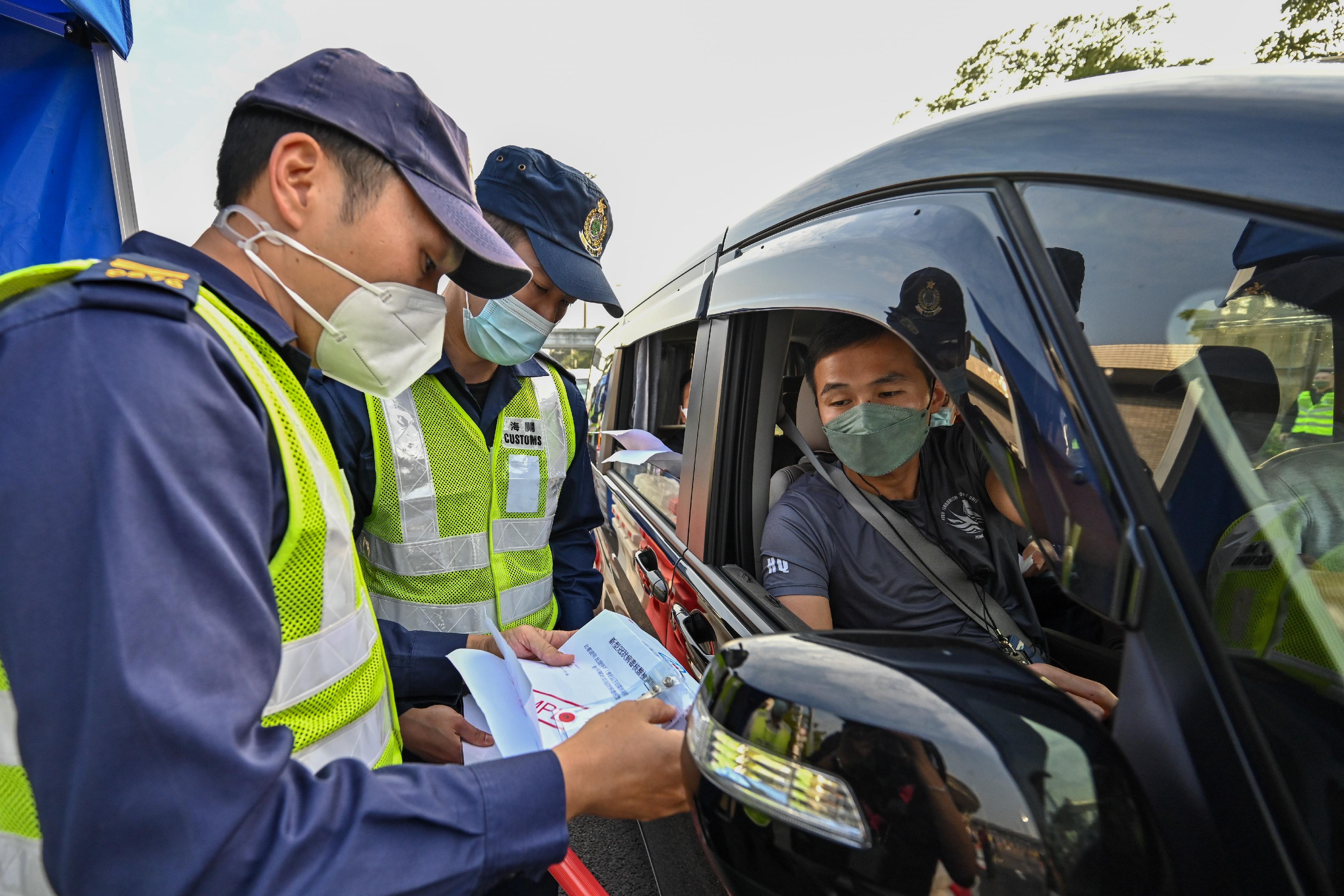 The Security Bureau led the disciplined services to conduct drills at Man Kam To Control Point, Lok Ma Chau Spur Line/Futian Control Point and Shenzhen Bay Control Point today (January 5) to ensure smooth operation of the control points at the beginning of the resumption of normal travel with the Mainland. Photo shows personnel of the Hong Kong Customs and simulated travellers taking part in the drill at Shenzhen Bay Control Point.