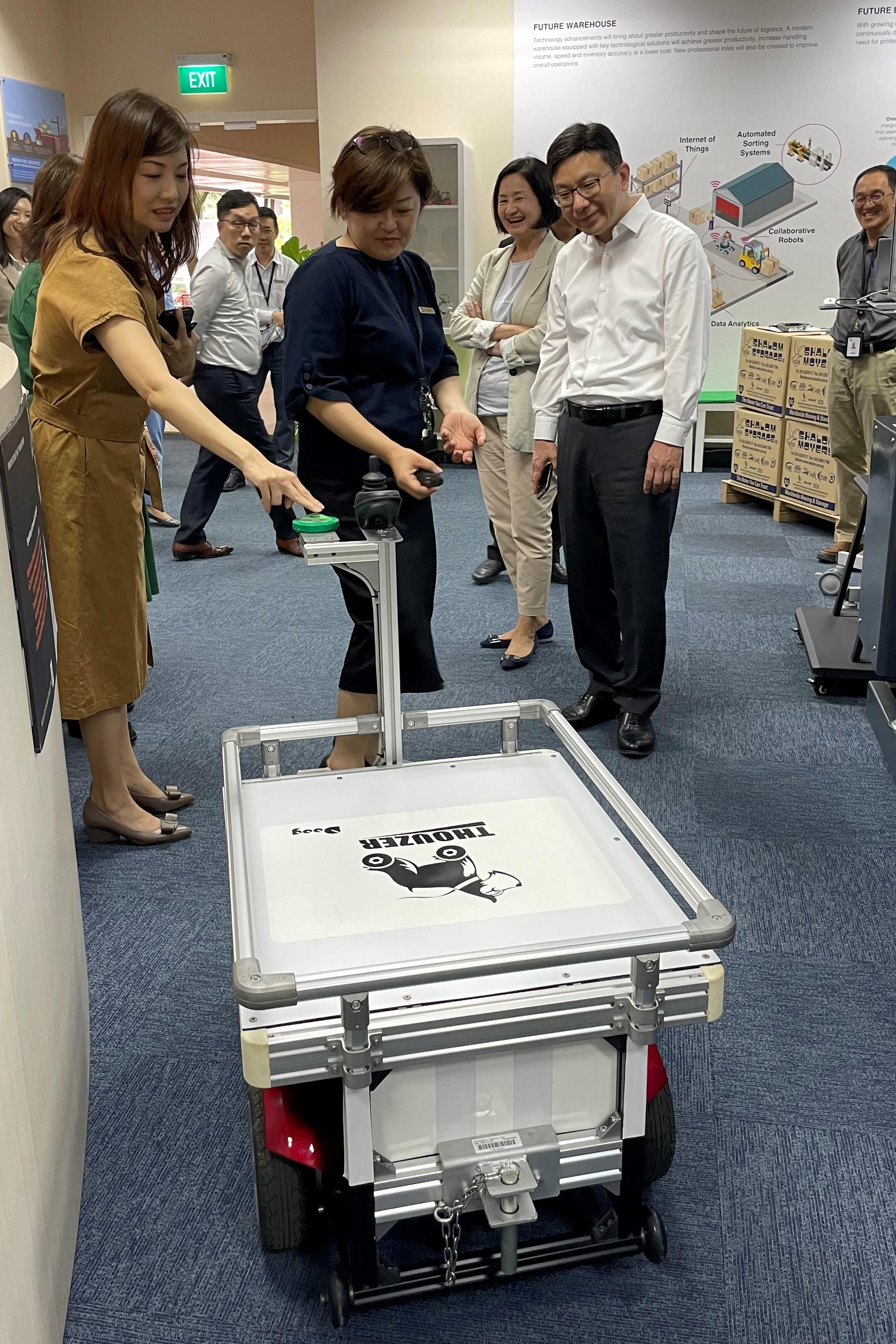The Secretary for Labour and Welfare, Mr Chris Sun, visited the Institute of Technical Education yesterday afternoon (January 6) during his visit to Singapore to take a closer look at innovation and technology solutions for the sustainable development of human resources. Photo shows Mr Sun (front row, right) watching a demonstration in the "future warehouse" on how a collaborative robotic cart aids loading and transportation, thereby improving the volume and efficiency.