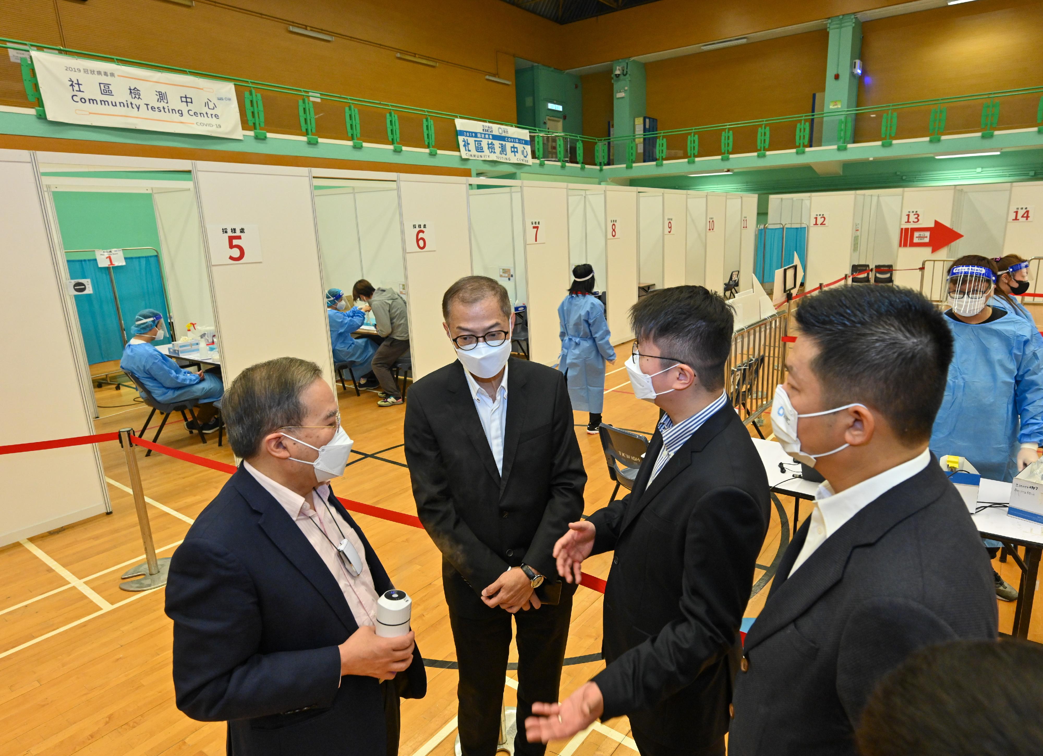 The Secretary for Health, Professor Lo Chung-mau, visited the community testing centre (CTC) located at To Kwa Wan Sports Centre this morning (January 9) to have a better grasp of its operation and the situation of members of the public undergoing tests there. Photo shows Professor Lo (second left) receiving a briefing by the persons-in-charge of the CTC on its operation.
