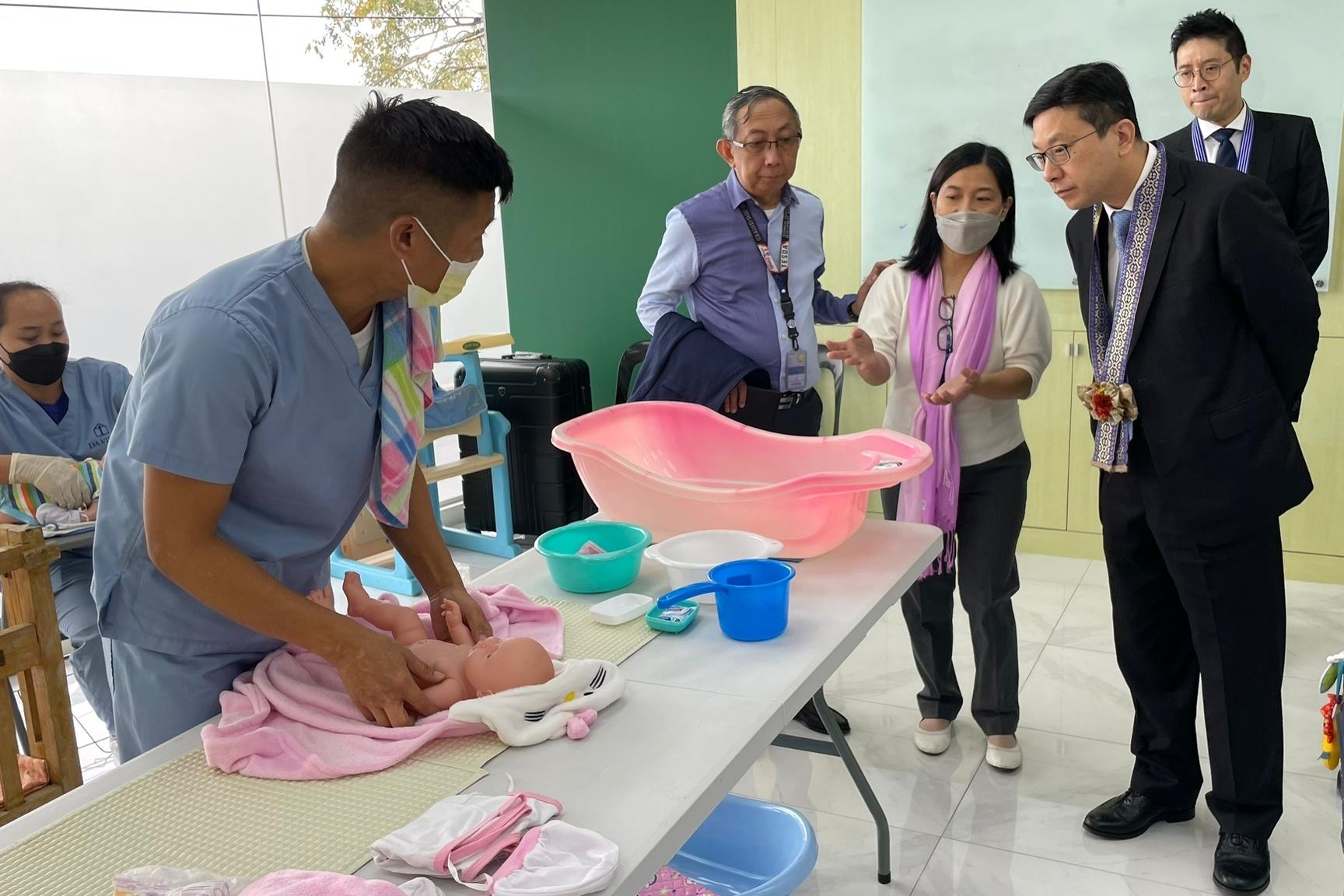 The Secretary for Labour and Welfare, Mr Chris Sun, visited a training facility under the Technical Education and Skills Development Authority this morning (January 10) during his visit to Manila, the Philippines, to take a closer look at the training of care workers. Photo shows Mr Sun (first right) watching a trainee's demonstration of bathing newborn babies.