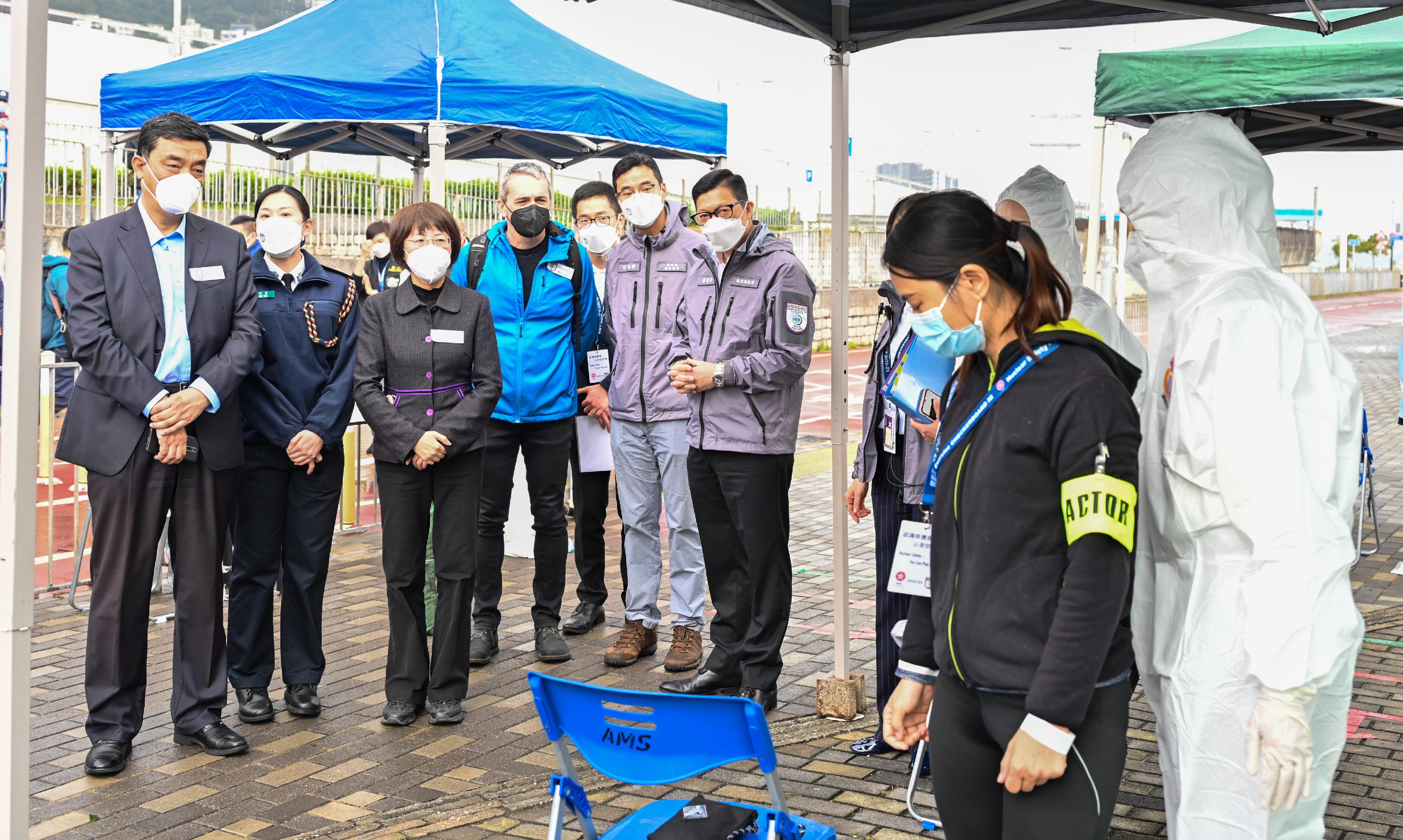 The Government conducted an inter-departmental exercise, "Checkerboard III", today (January 12). Photo shows the Secretary for Security, Mr Tang Ping-keung (third right); the Vice Minister of the Ministry of Ecology and Environment, Administrator of National Nuclear Safety Administration, Mr Dong Baotong (first left); the Response System Officer of the Incident and Emergency Centre of the International Atomic Energy Agency, Mr Guenther Winkler (fourth left); and other experts observing personnel of the Auxiliary Medical Service conducting radiation checking on an evacuee at Ma Liu Shui Ferry Pier.