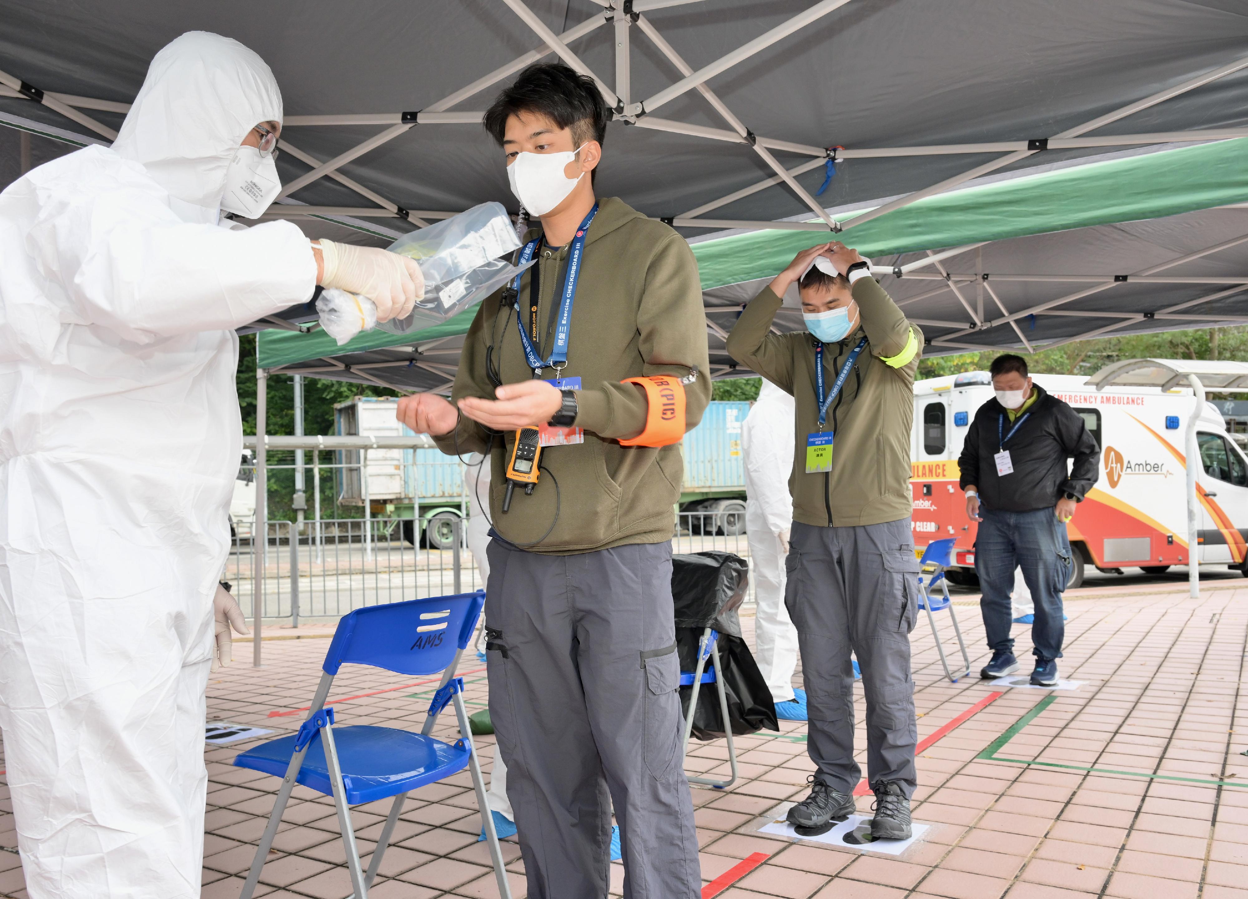 The Government conducted an inter-departmental exercise, "Checkerboard III", today (January 12). Photo shows staff members of the Auxiliary Medical Service simulating radiation monitoring on people arriving from the Mainland at Man Kam To Control Point.