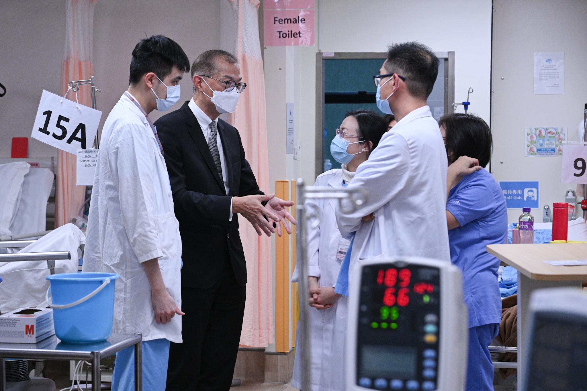 The Secretary for Health, Professor Lo Chung-mau, visited Queen Mary Hospital today (January 13). Photo shows Professor Lo (second left) chatting with the frontline healthcare staff. 

