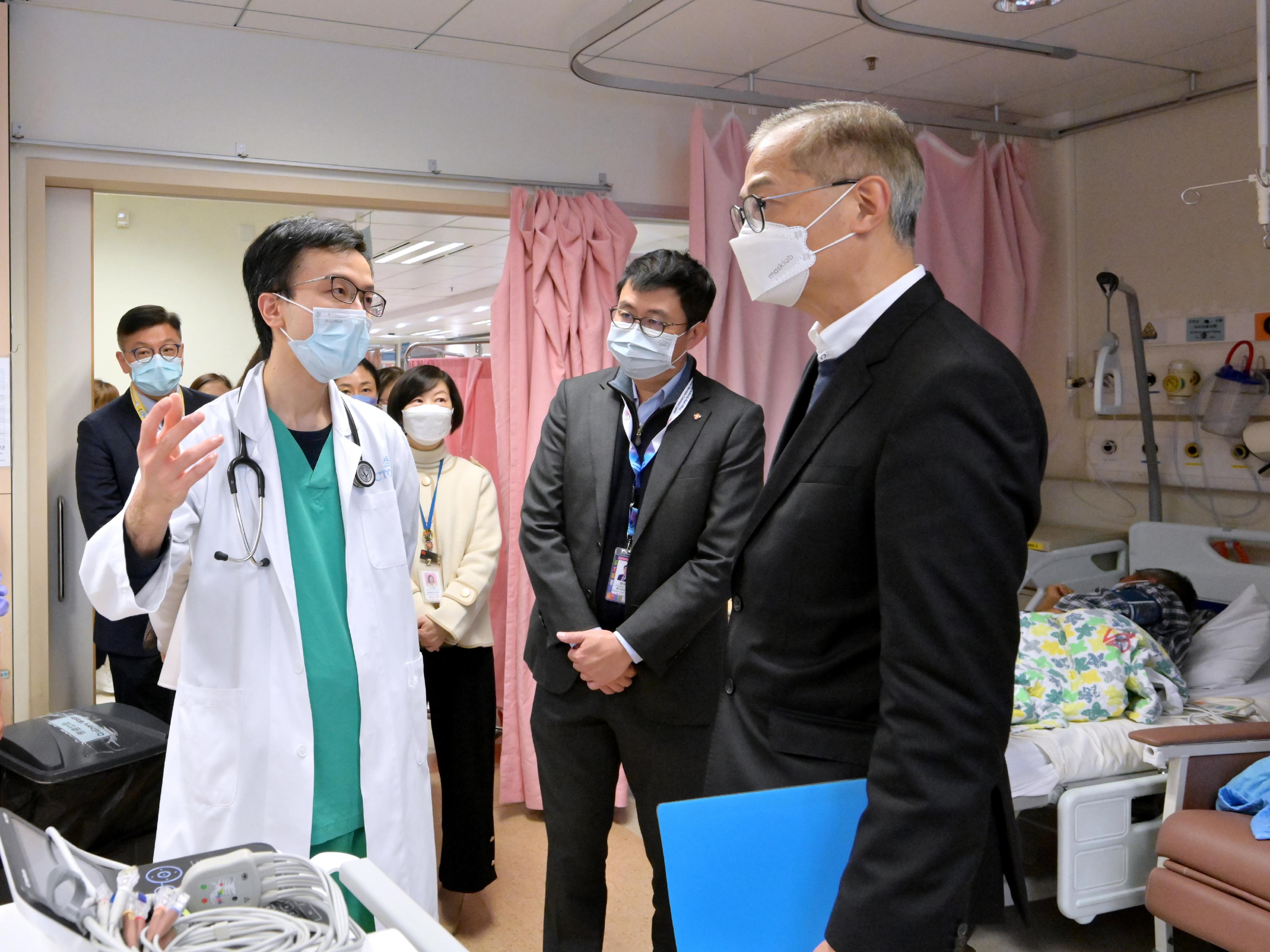 醫務衞生局局長盧寵茂教授（右）今日（一月十六日）視察威爾斯親王醫院，向前線醫護人員了解他們在該院內科病房日常照顧病人的工作。
