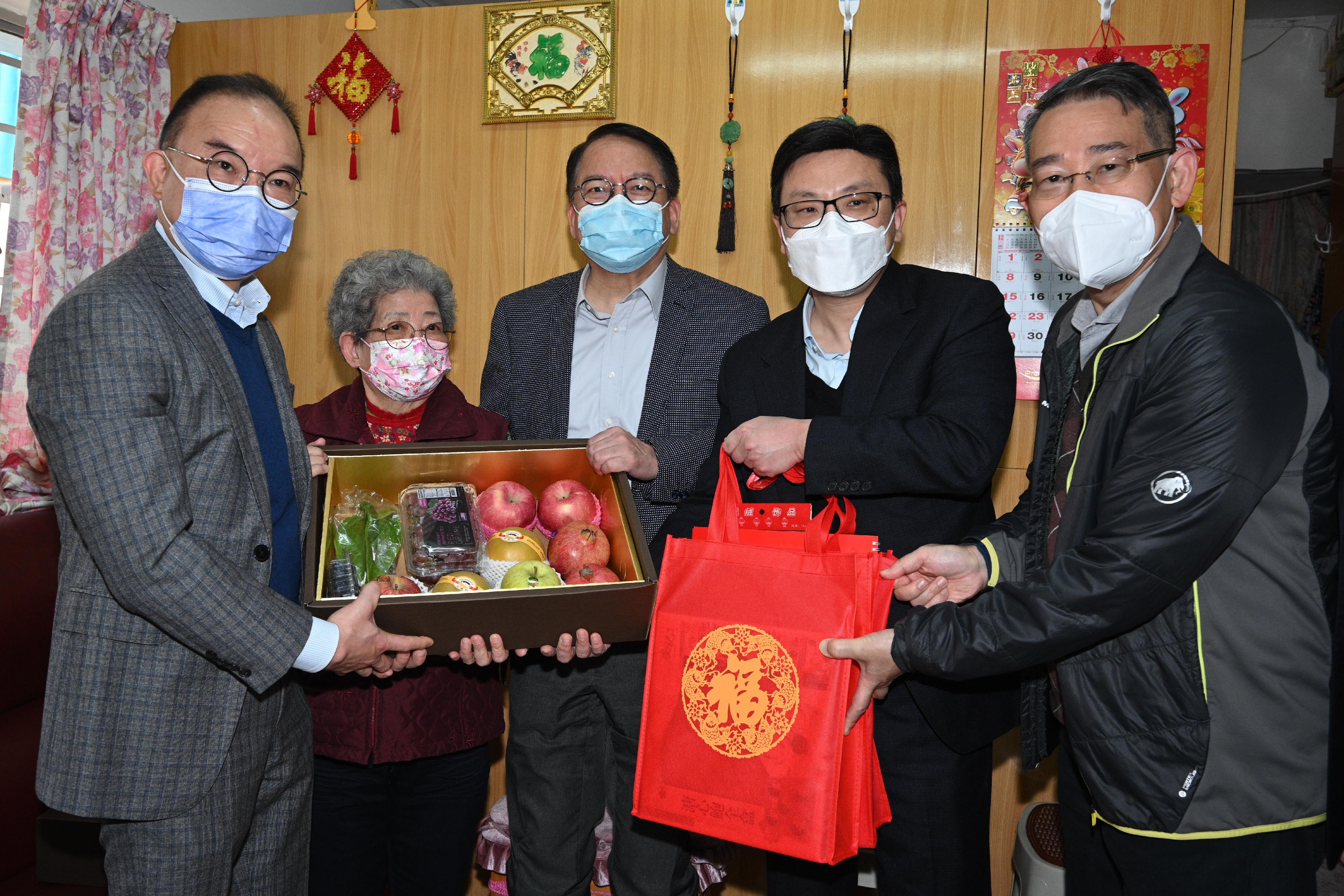The Chief Secretary for Administration, Mr Chan Kwok-ki, and the Deputy Chief Secretary for Administration, Mr Cheuk Wing-hing, together with a number of Principal Officials, visited grass-roots families in the Eastern District to distribute Chinese New Year blessing bags and celebrate Chinese New Year with them today (January 21). Photo shows Mr Chan (centre); the Secretary for Constitutional and Mainland Affairs, Mr Erick Tsang Kwok-wai (first left); the Secretary for Labour and Welfare, Mr Chris Sun (second right); and the District Officer (Eastern), Mr Simon Chan (first right), presenting a blessing bag to an elderly singleton.