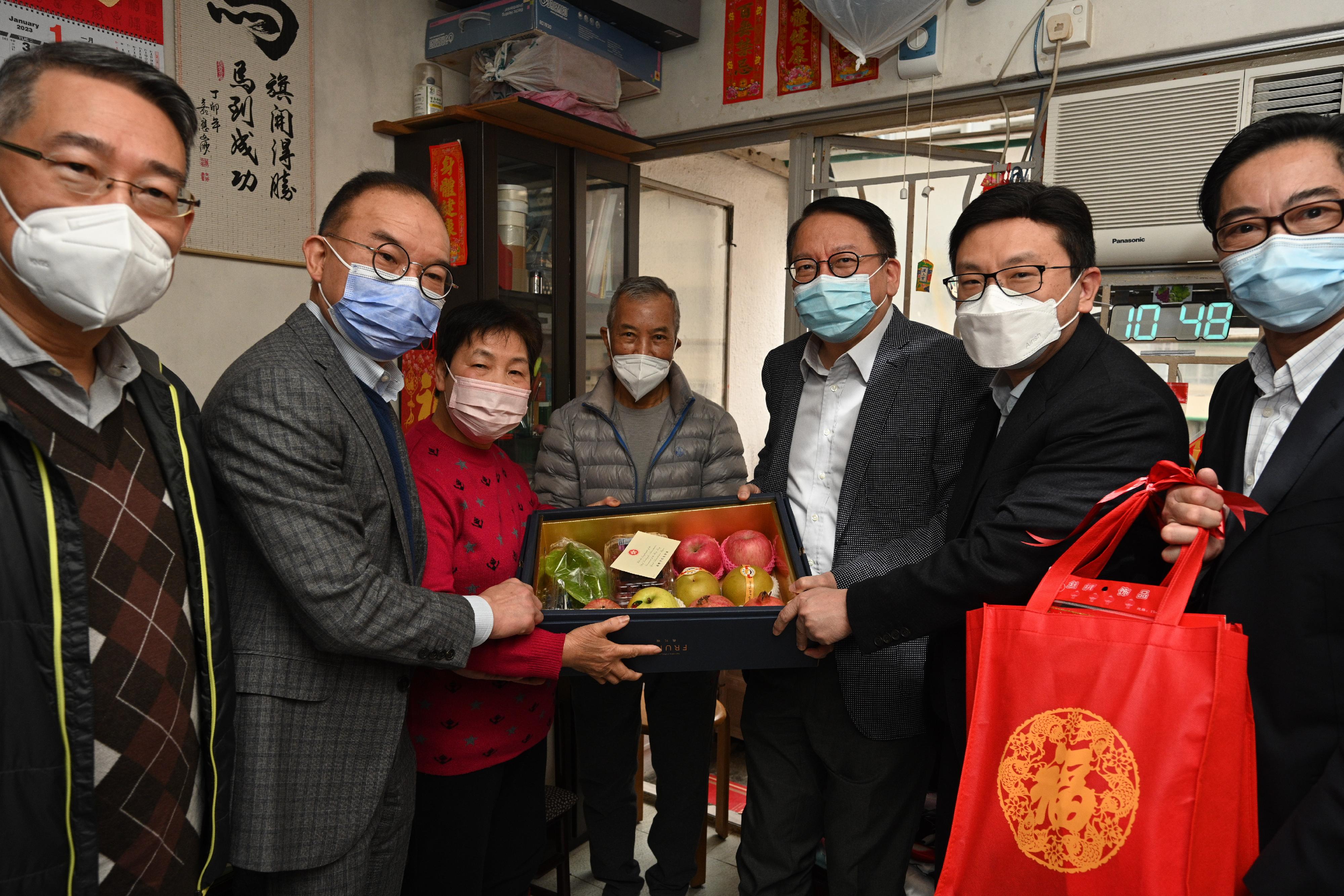 The Chief Secretary for Administration, Mr Chan Kwok-ki, and the Deputy Chief Secretary for Administration, Mr Cheuk Wing-hing, together with a number of Principal Officials, visited grass-roots families in the Eastern District to distribute Chinese New Year blessing bags and celebrate Chinese New Year with them today (January 21). Photo shows Mr Chan (third right); the Secretary for Constitutional and Mainland Affairs, Mr Erick Tsang Kwok-wai (second left); the Secretary for Labour and Welfare, Mr Chris Sun (second right); the District Officer (Eastern), Mr Simon Chan (first left); and North Point East Area Committee Member Mr Cheng Chi-sing (first right), presenting a blessing bag to an elderly singleton.