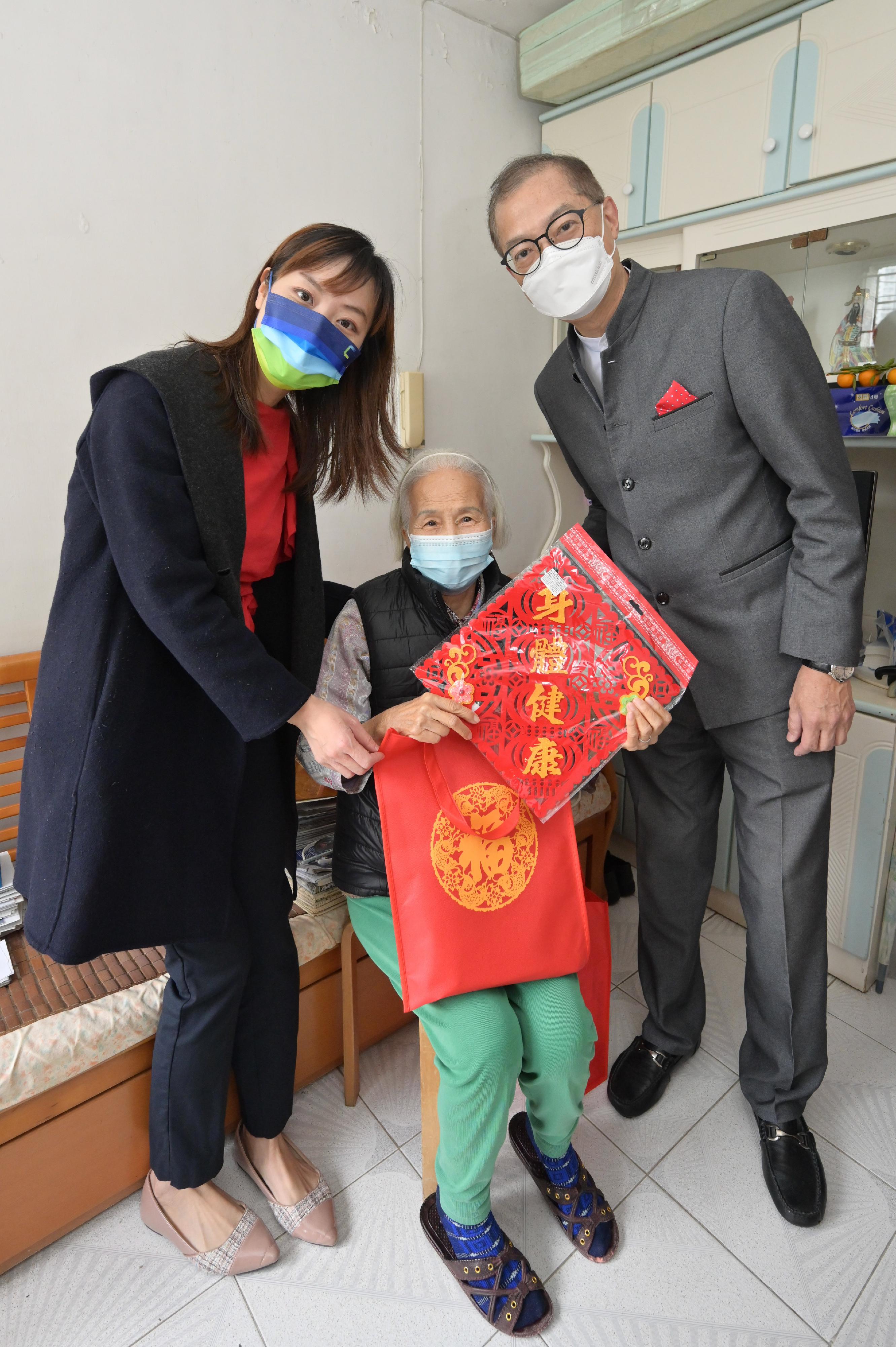 The Deputy Secretary for Justice, Mr Cheung Kwok-kwan, together with a number of the Principal Officials today (January 23) visited grass-roots families in Wong Tai Sin District to distribute blessing bags and celebrate Chinese New Year with them.  Photo shows the Secretary for Health, Professor Lo Chung-mau (right) and the Acting Secretary for Innovation, Technology and Industry, Ms Lillian Cheong (left) distributing blessing bag to a singleton to share with her the festive joy.