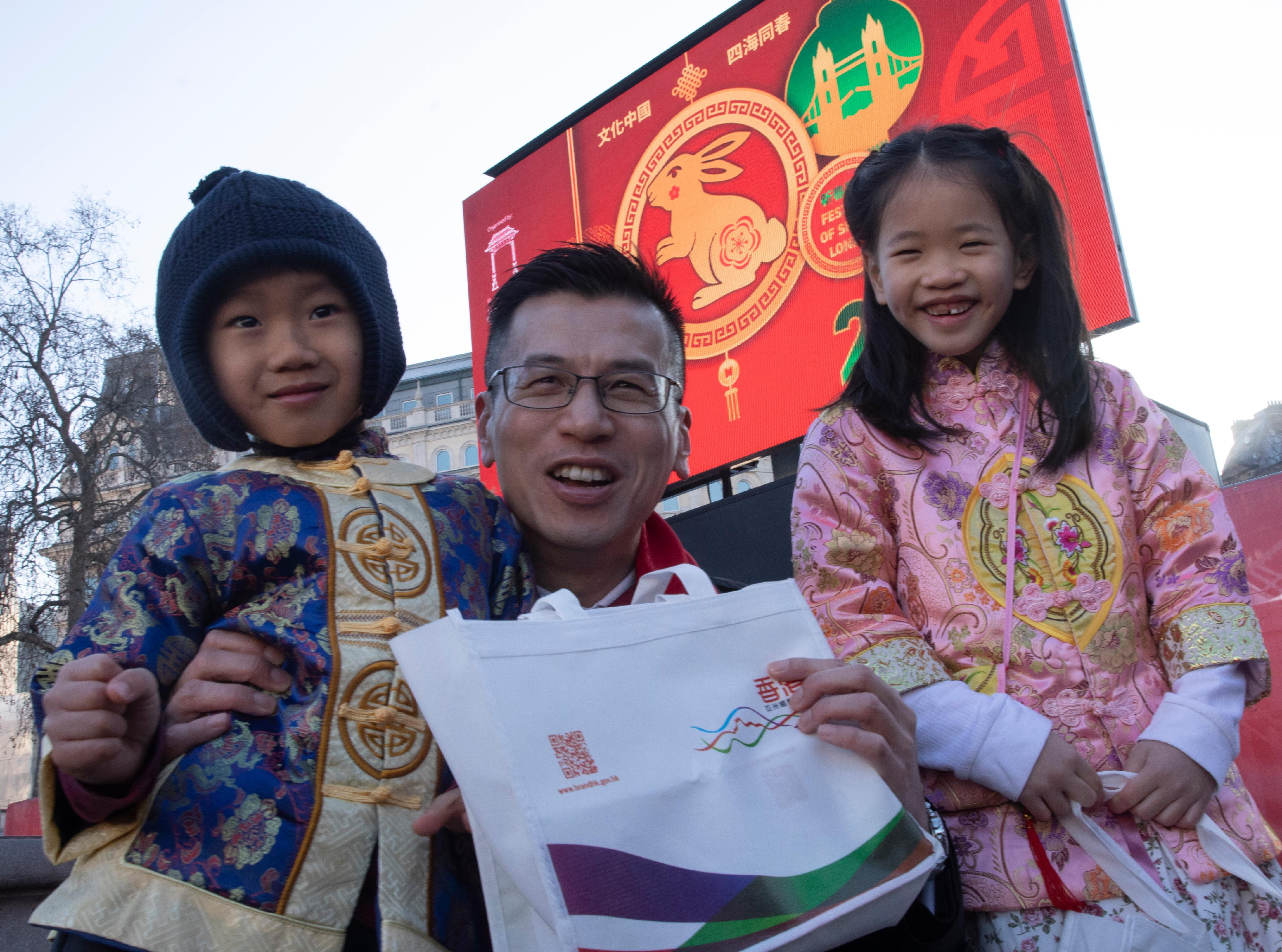 The Hong Kong Economic and Trade Office, London (London ETO) participated in a large-scale London Chinatown celebration in Trafalgar Square, Chinatown and Charing Cross Road on January 22 (London time). Photo shows the Director-General of the London ETO, Mr Gilford Law (centre), greeting local audience with souvenirs at Trafalgar Square.