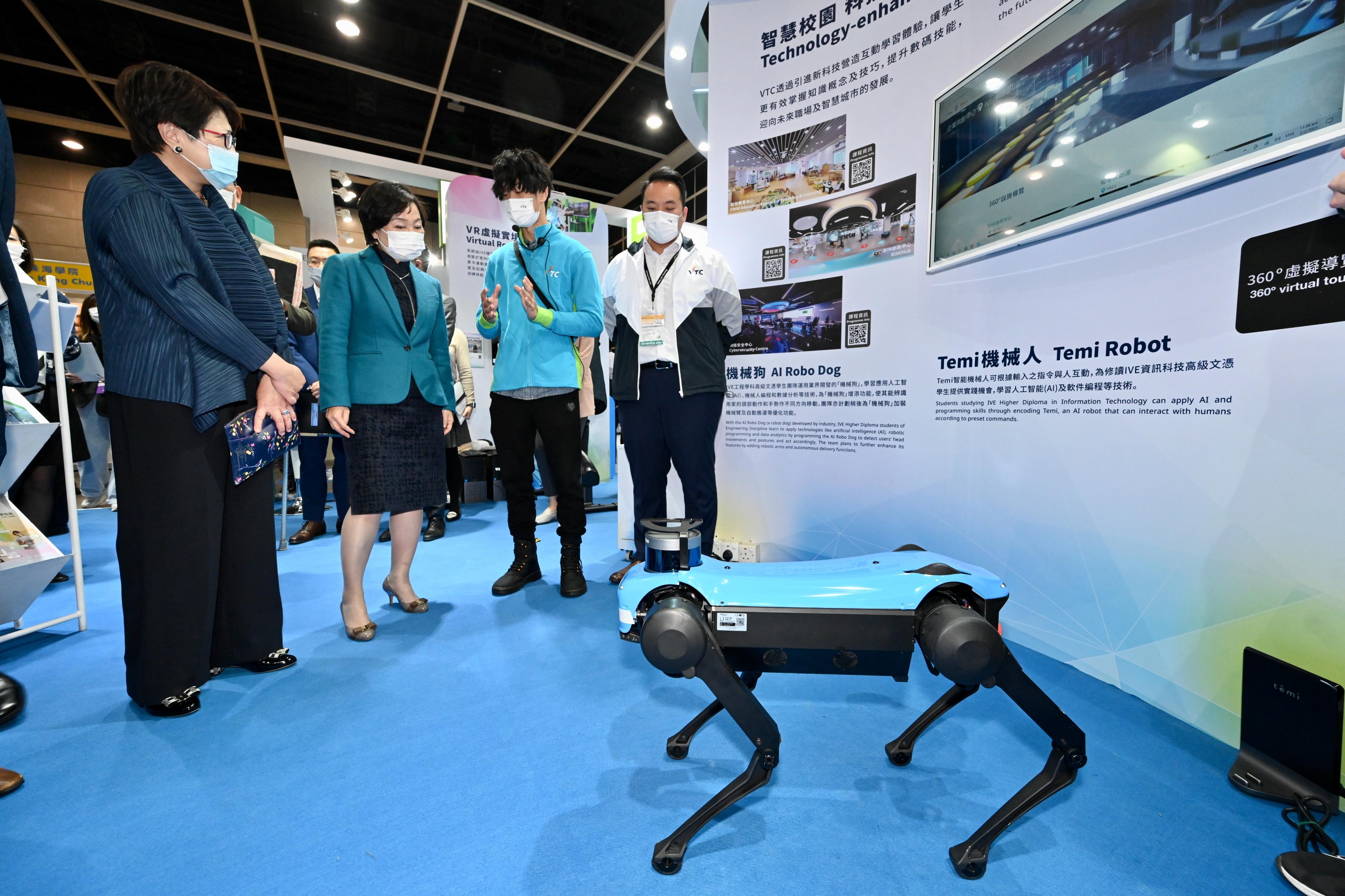 The Secretary for Education, Dr Choi Yuk-lin (second left), is being briefed by a representative of the Vocational Training Council on an AI Robo Dog at the Education & Careers Expo 2023 today (February 2).   