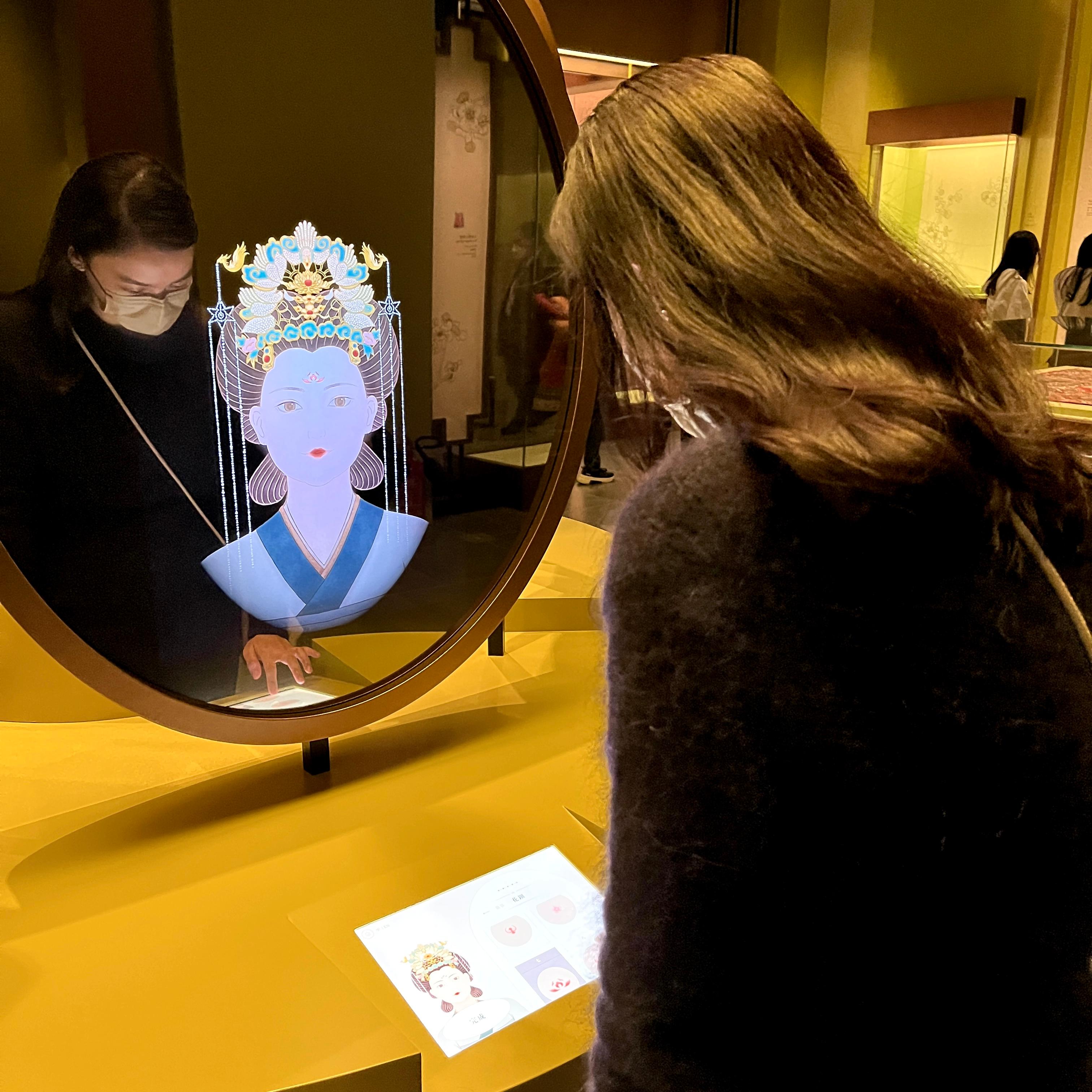 現正於香港文化博物館舉行的「香港賽馬會呈獻系列：眾裡尋她——南京博物院藏中國古代女性文物展」二月二十七日 （星期一）結束，市民請把握機會參觀這個不容錯過的展覽。圖示展廳內的互動裝置，參觀者可自由配搭古代女性的髮型、飾品及妝容。