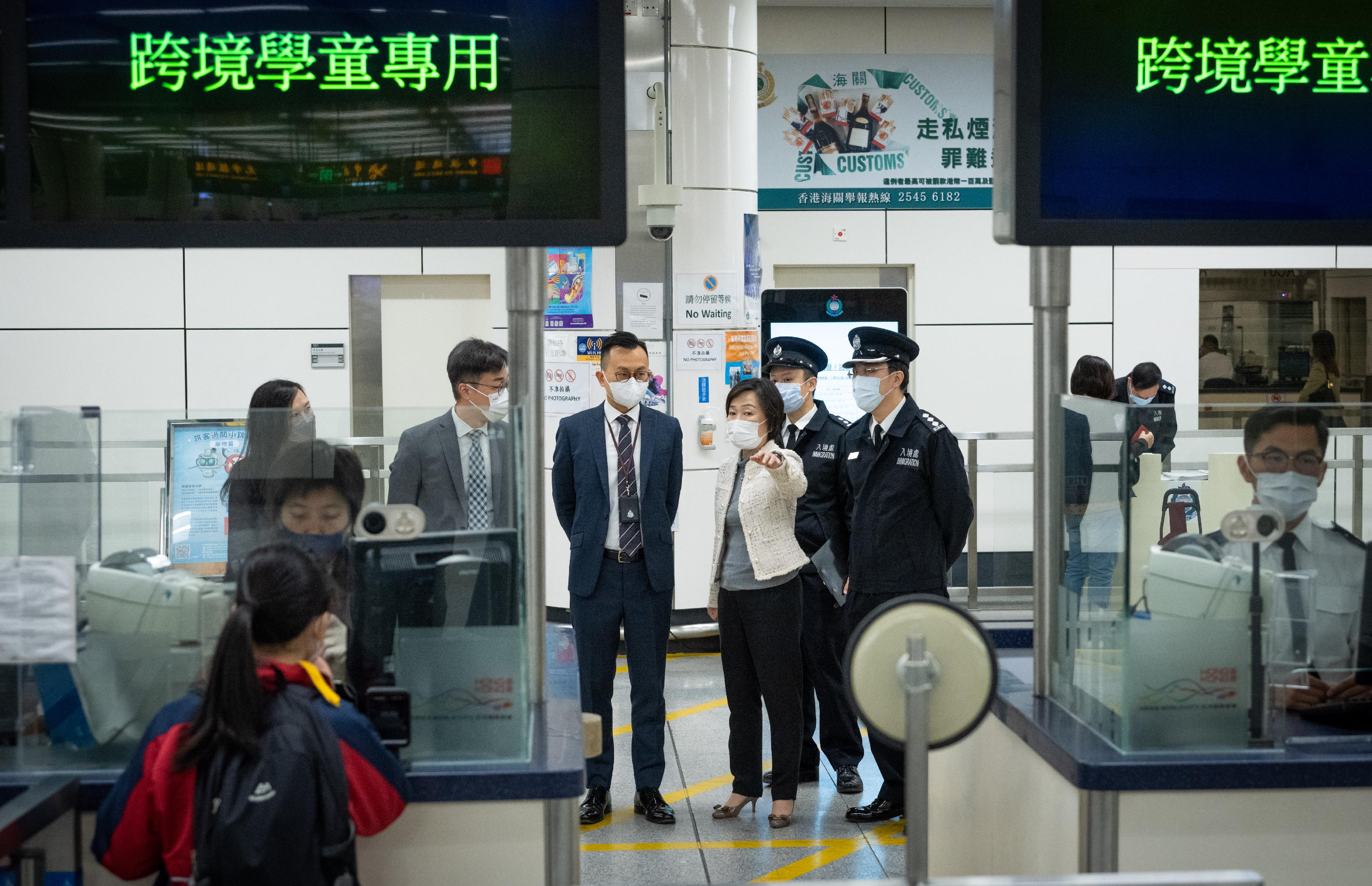 教育局局長蔡若蓮博士今早（二月八日）到訪深圳灣管制站，了解跨境學生過關的情況。圖示蔡若蓮博士（右三）聽取入境事務處人員簡介為跨境學生提供的便利過關服務。

