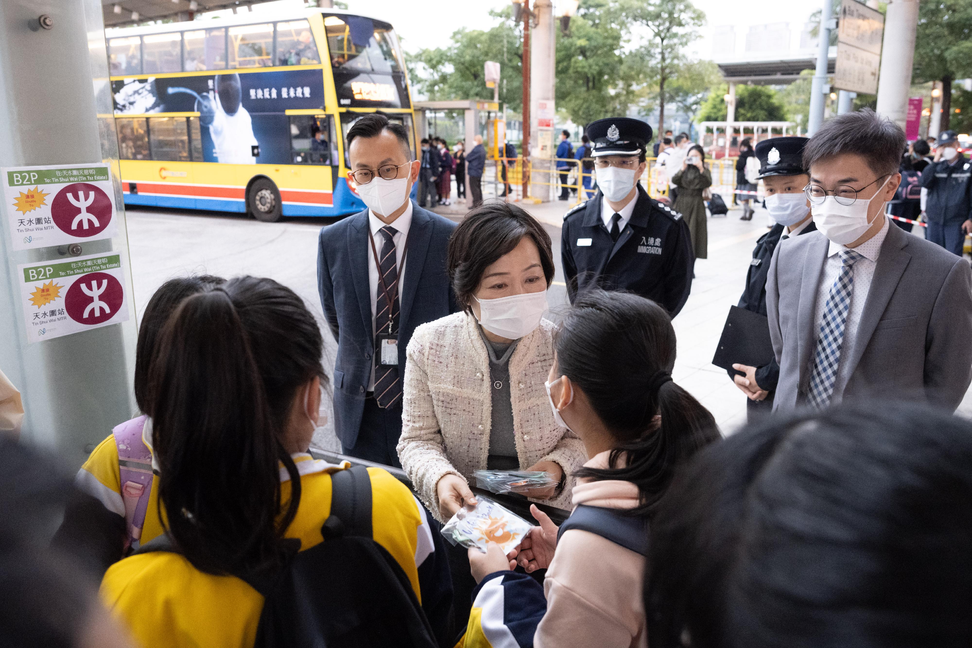 The Secretary for Education, Dr Choi Yuk-lin, visited the Shenzhen Bay Control Point this morning (February 8) to learn about the arrangements of boundary crossing for cross-boundary students and their use of public transport. Photo shows Dr Choi (second left) giving gift packs to students.
