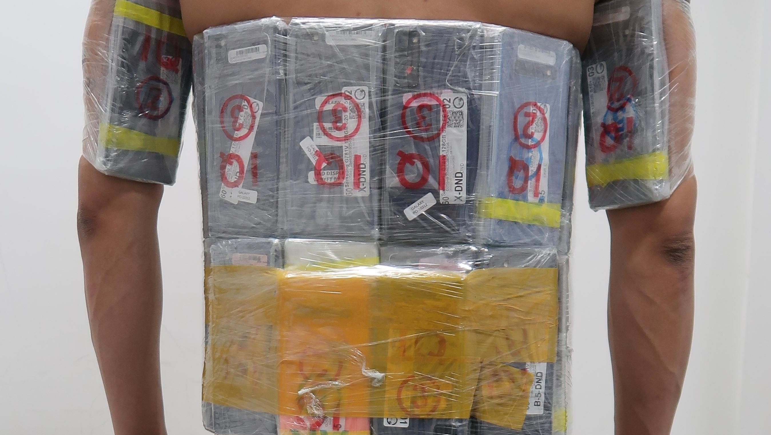 Hong Kong Customs yesterday (February 9) detected a suspected mobile phone smuggling case at the Shenzhen Bay Control Point and seized 40 mobile phones with an estimated market value of about $35,000. Photo shows the mobile phones strapped under a male passenger's armpits and around his waist, as found by Customs officers when conducting customs clearance.