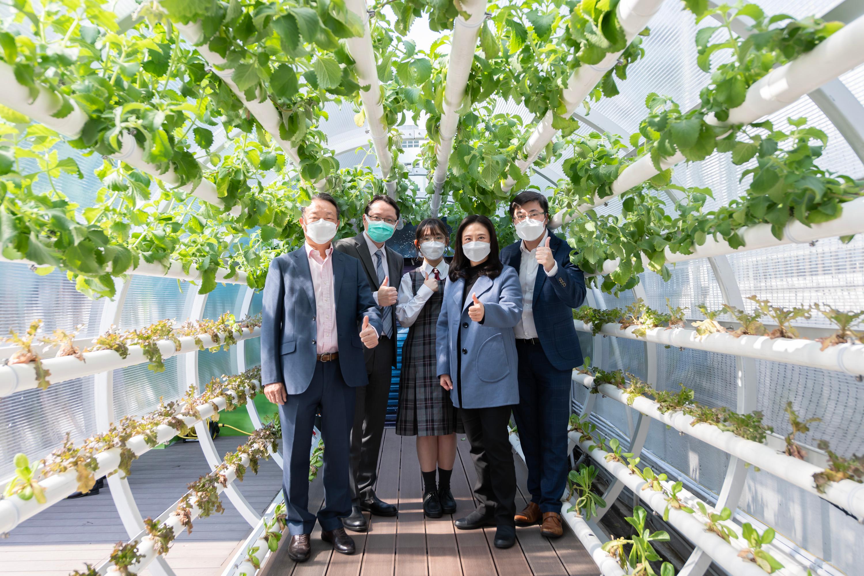 The Legislative Council Subcommittee on Matters Relating to the Development of Smart City visited the HKSKH Bishop Hall Secondary School today (February 24). Photo shows Members posing with representatives of the school at its 5G smart hydroponic farming site.
