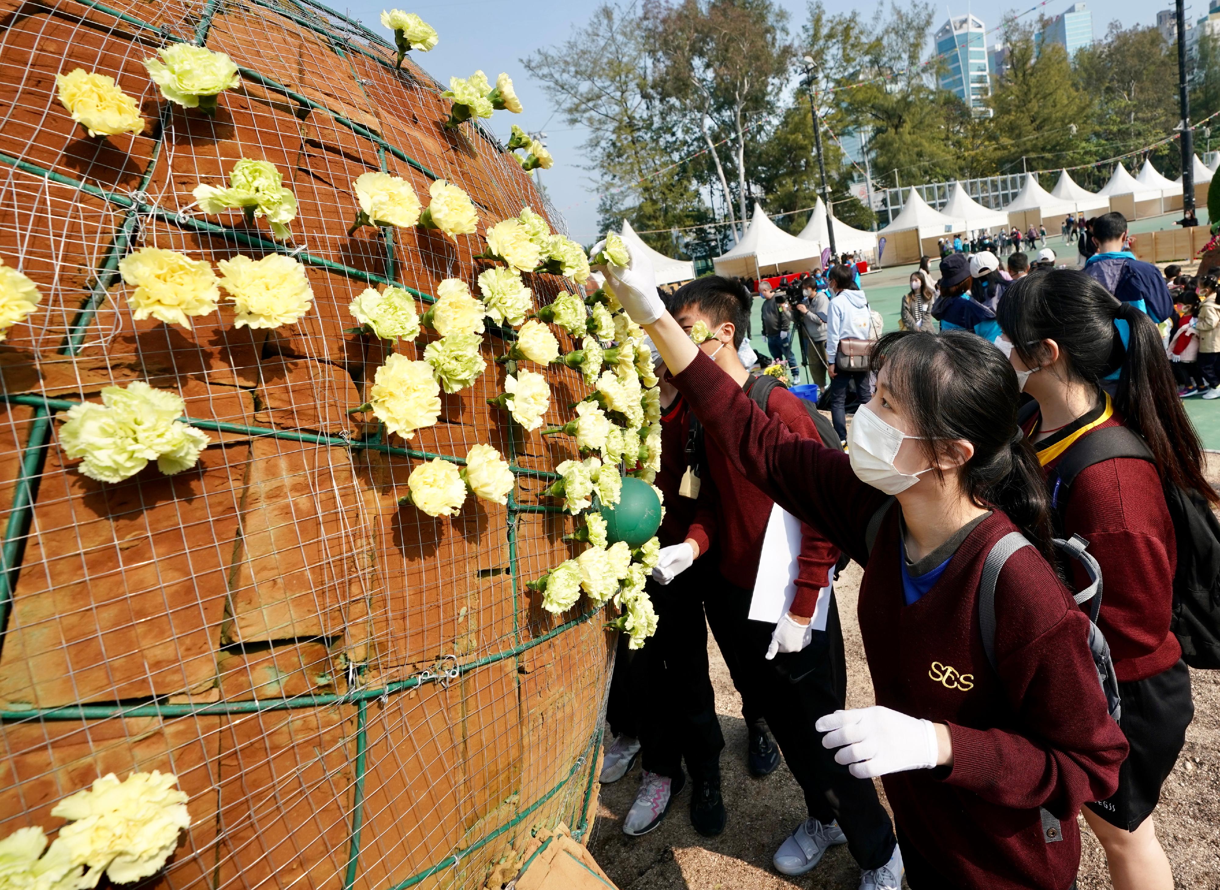 About 1 000 students from 32 schools worked together to help put on the spectacular horticultural display "Midsummer Jubilation" at Victoria Park today (February 25). Photo shows students working on the horticultural display.