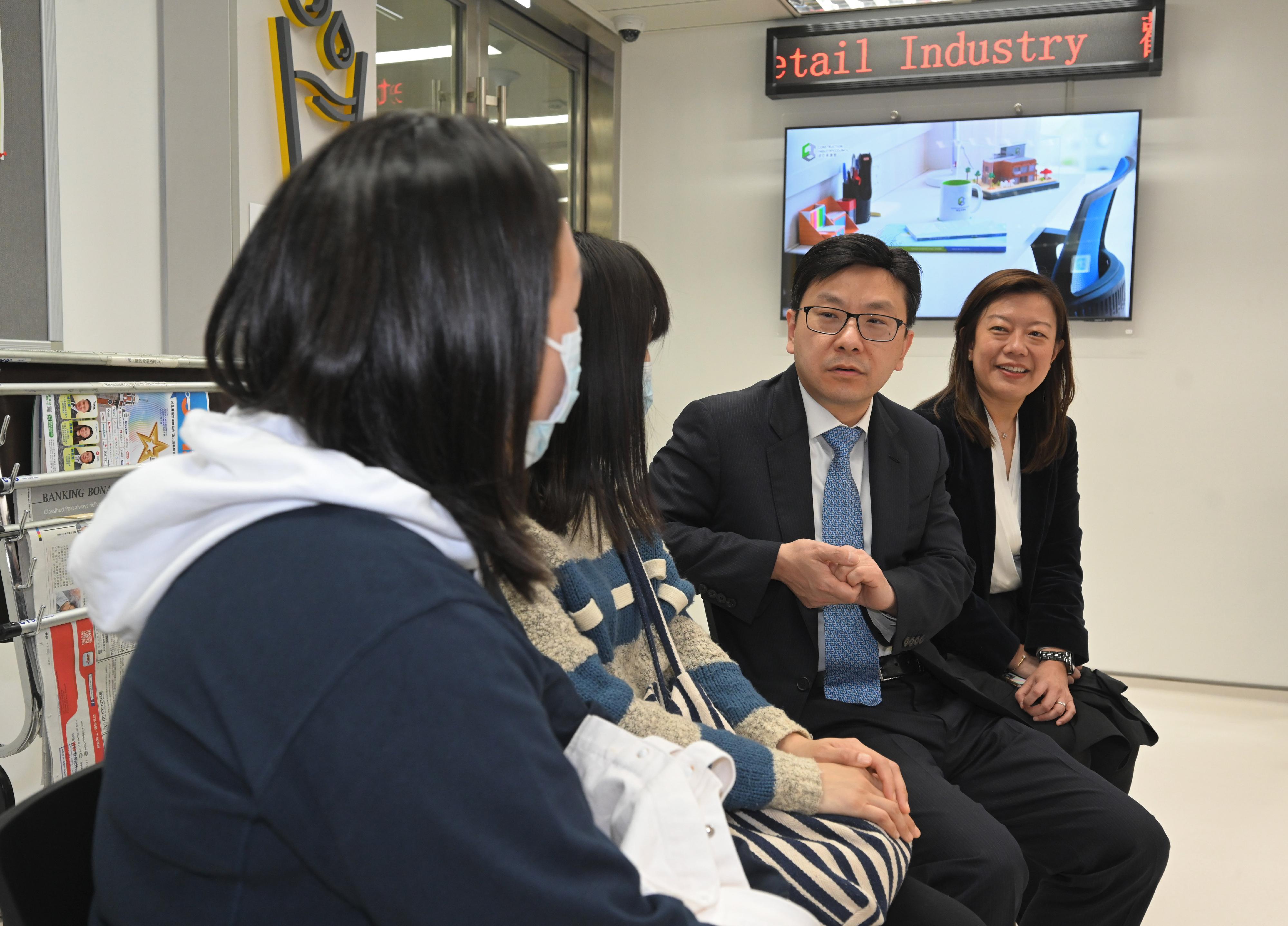 The Secretary for Labour and Welfare, Mr Chris Sun, today (March 1) visited the Recruitment Centre for the Catering Industry and the Recruitment Centre for the Retail Industry at the Treasury Building in Cheung Sha Wan to take a closer look at the enhanced employment services of the Labour Department upon resumption of economic activities following the lifting of all mandatory mask-wearing requirements in Hong Kong. The Commissioner for Labour, Ms May Chan, also joined the visit. Photo shows Mr Sun (second right) and Ms Chan (first right) listening to job seekers sharing their job searching experiences.