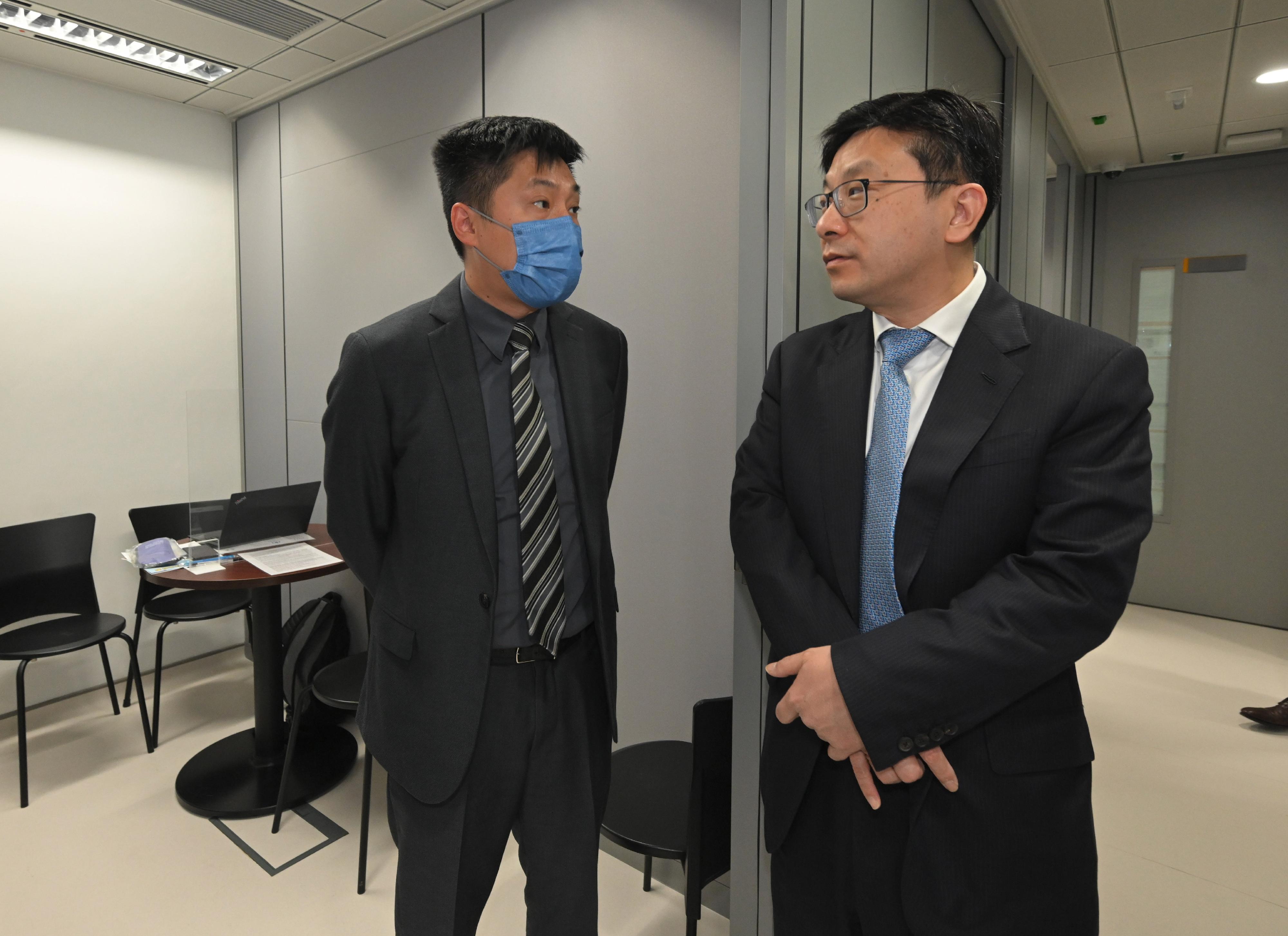 The Secretary for Labour and Welfare, Mr Chris Sun, today (March 1) visited the Recruitment Centre for the Catering Industry and the Recruitment Centre for the Retail Industry at the Treasury Building in Cheung Sha Wan to take a closer look at the enhanced employment services of the Labour Department upon resumption of economic activities following the lifting of all mandatory mask-wearing requirements in Hong Kong. The Commissioner for Labour, Ms May Chan, also joined the visit. Photo shows Mr Sun (right) learning more about recent recruitment activities and the latest manpower conditions of individual job titles from an employer representative in an interview room.