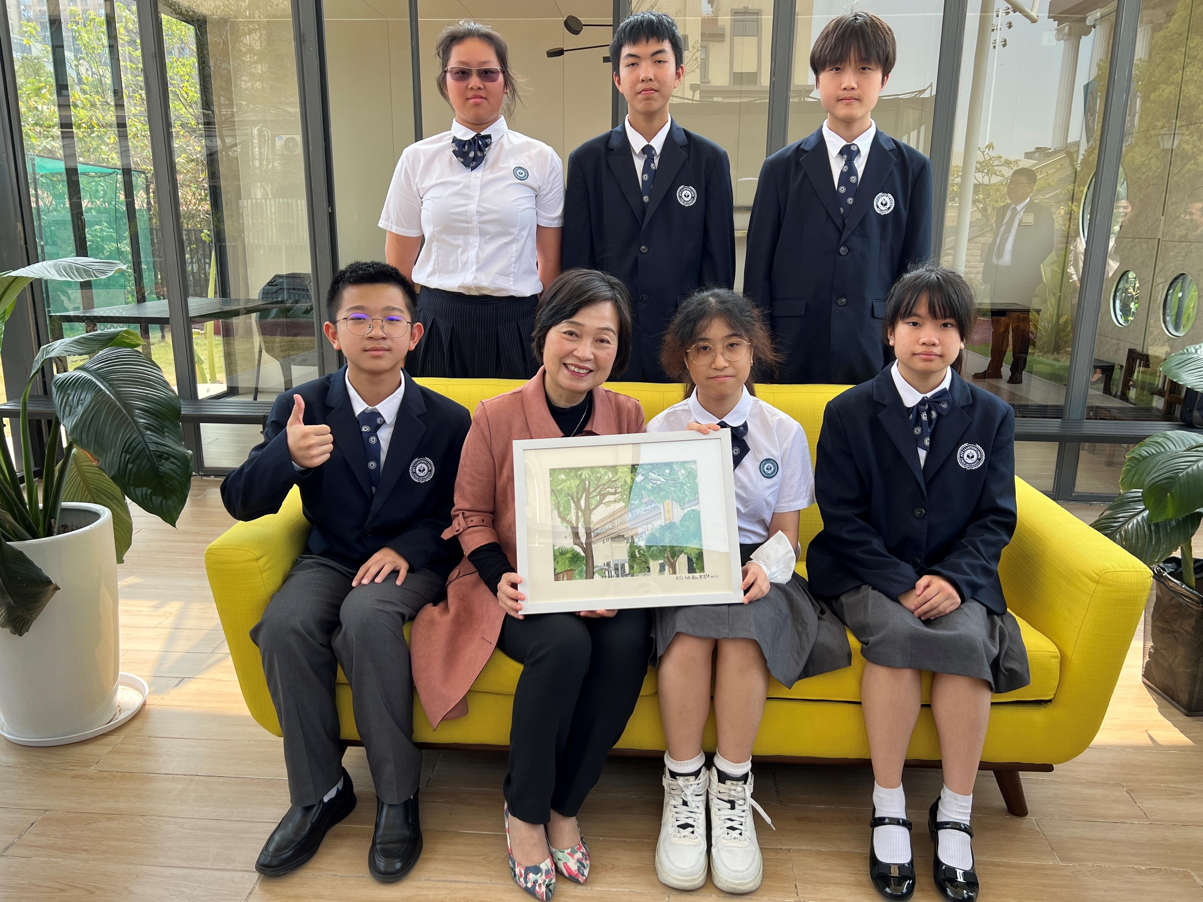 The Secretary for Education, Dr Choi Yuk-lin, today (March 8) visited the Affiliated School of JNU for Hong Kong and Macao Students in Dongguan to understand more about the study situation of children of Hong Kong people on the Mainland. Photo shows Dr Choi (front row, second left) receiving a souvenir from students of the school.