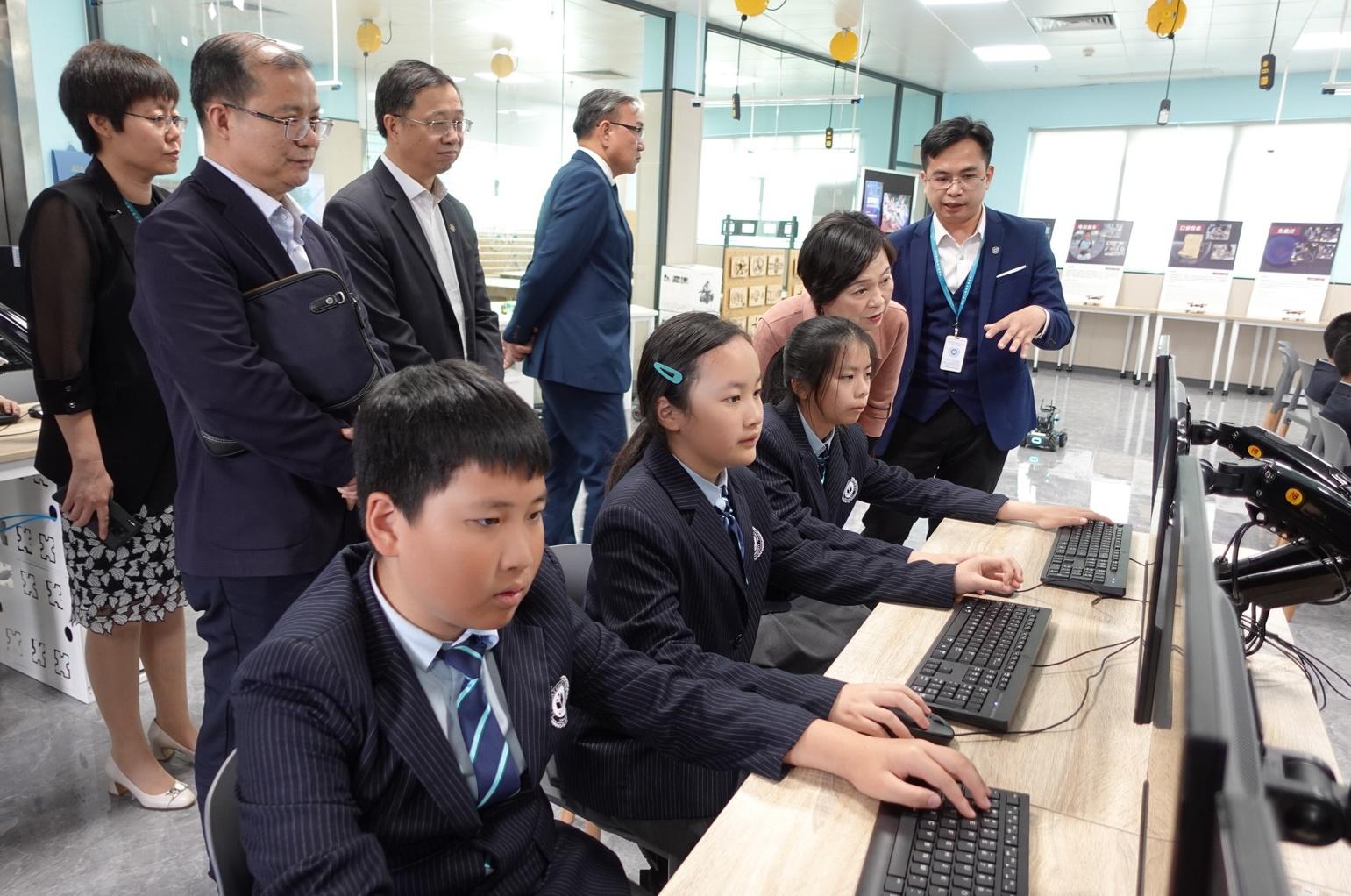 The Secretary for Education, Dr Choi Yuk-lin, today (March 8) visited the Affiliated School of JNU for Hong Kong and Macao Students in Guangzhou to understand more about the study situation of children of Hong Kong people on the Mainland. Photo shows Dr Choi (front row, second right) observing students learning robotics technologies.