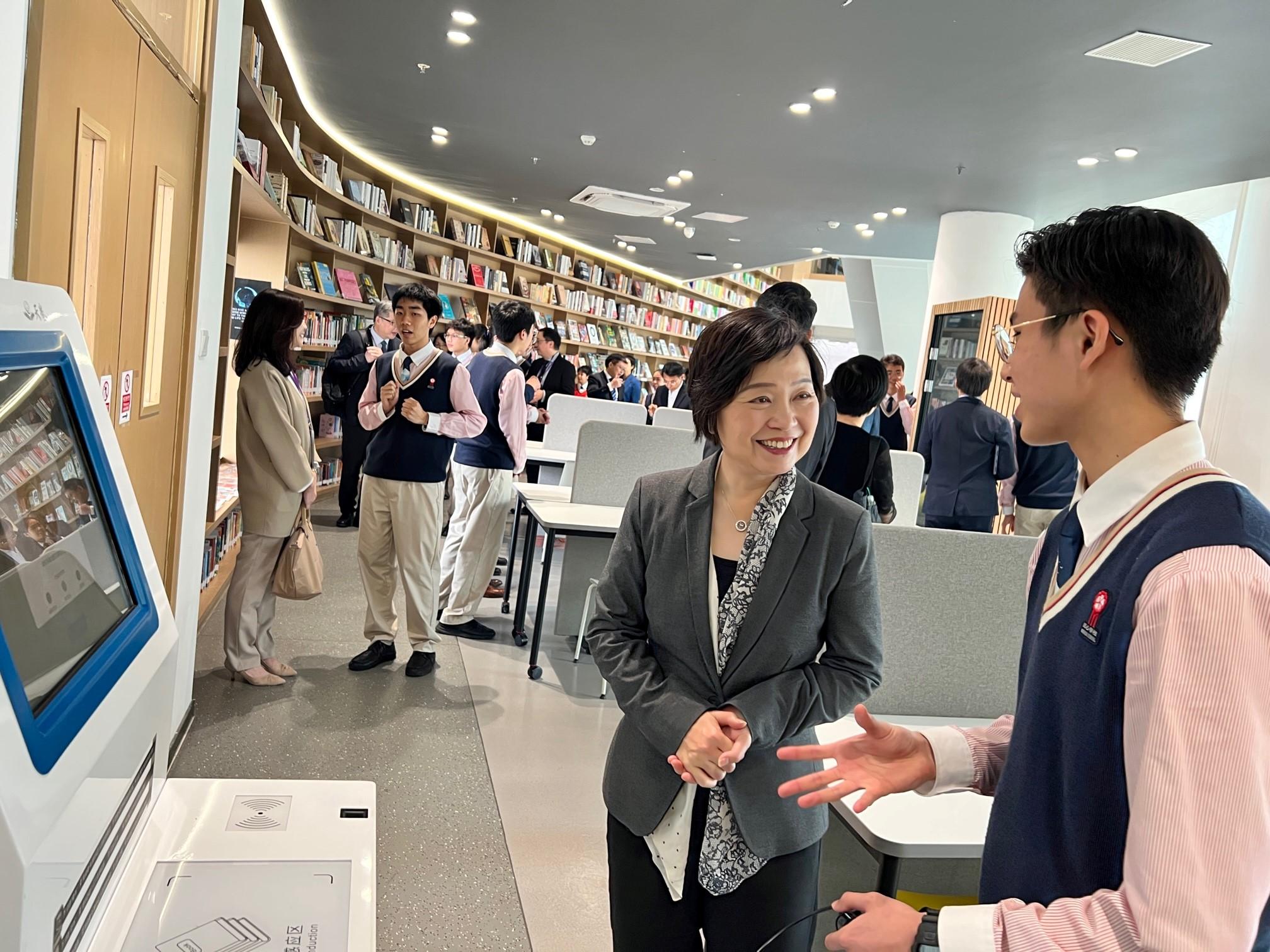 The Secretary for Education, Dr Choi Yuk-lin, visited Minxin Hong Kong School (Guangzhou Nansha) today (March 10) to understand more about the study situation of Hong Kong students on the Mainland. Photo shows Dr Choi (left) being briefed by a student on the library facilities.