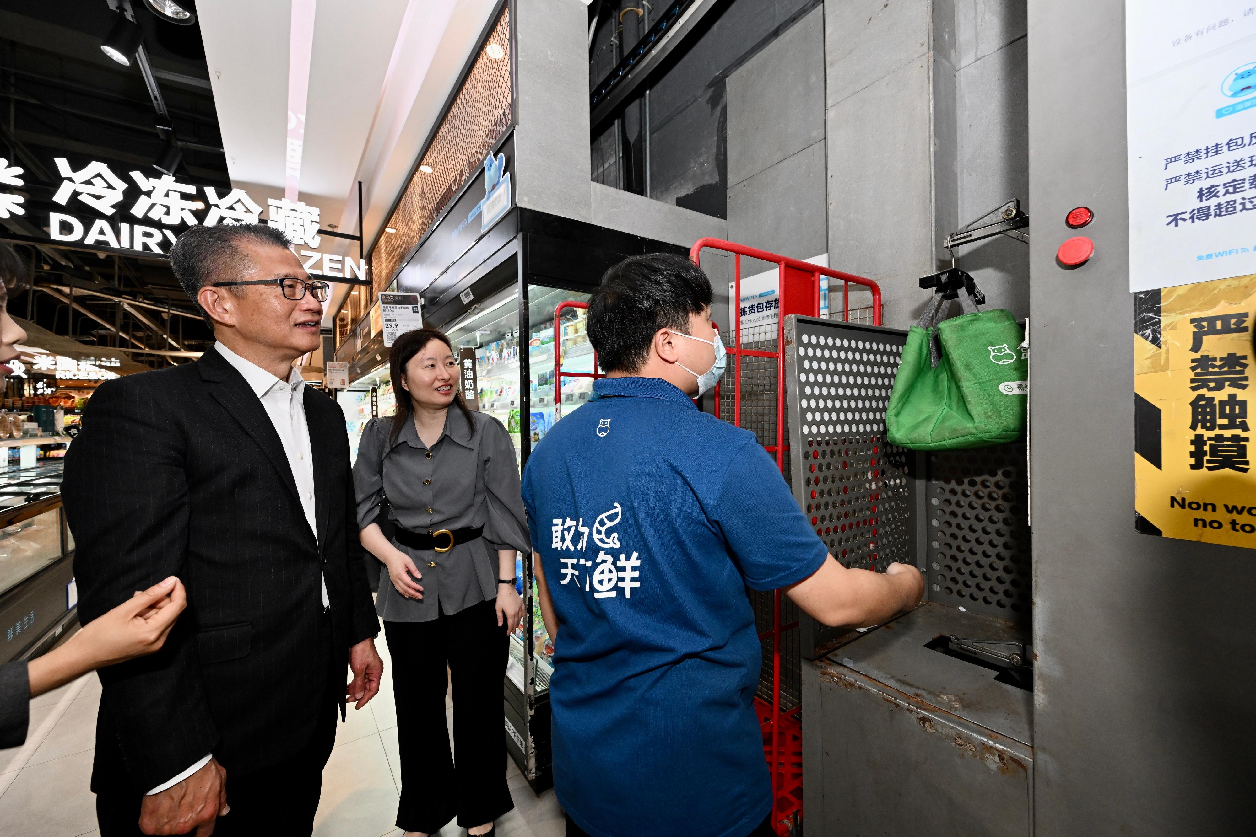 財政司司長陳茂波（左一）今日（三月十五日）到訪廣州市的盒馬網路科技有限公司，了解該公司如何應用大數據、人工智能和物流科技，加速新鮮食品和產品的配送。