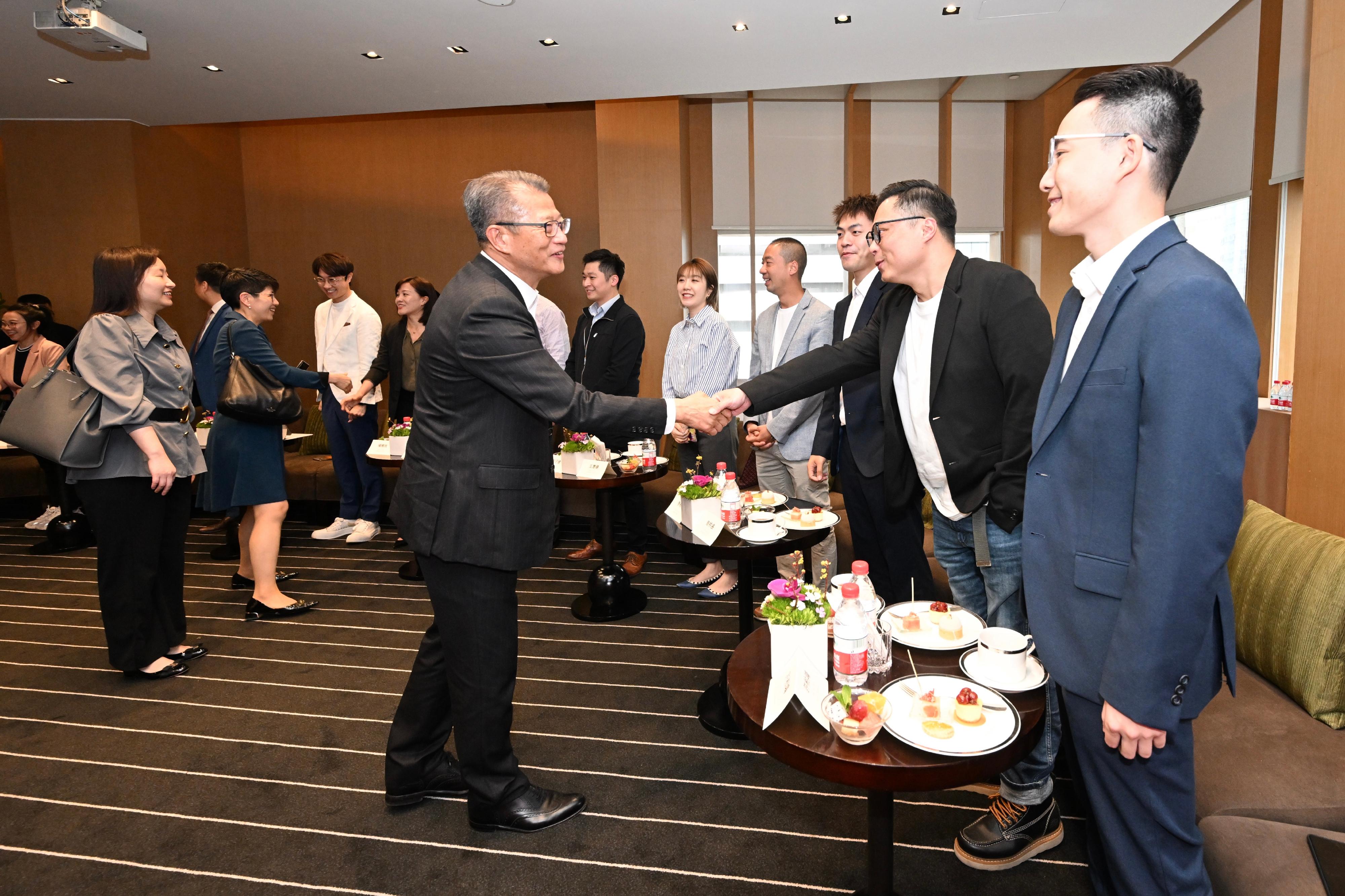 The Financial Secretary, Mr Paul Chan (left), meets with the Hong Kong young entrepreneurs in Guangzhou today (March 15) and exchanges views with them. 