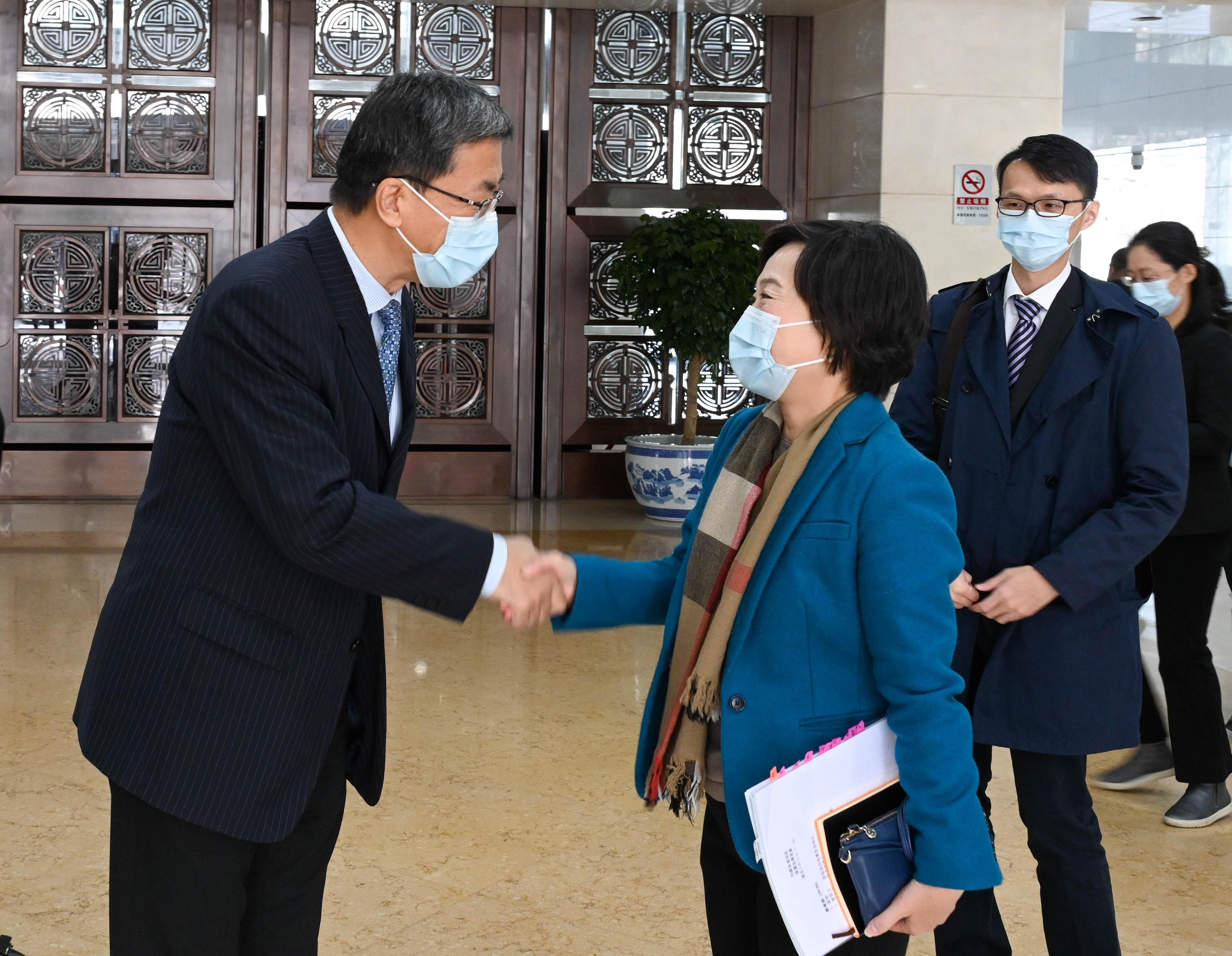 The Secretary for Education, Dr Choi Yuk-lin (right), is greeted by the Minister of Education, Mr Huai Jinpeng (left), in Beijing this morning (March 16).