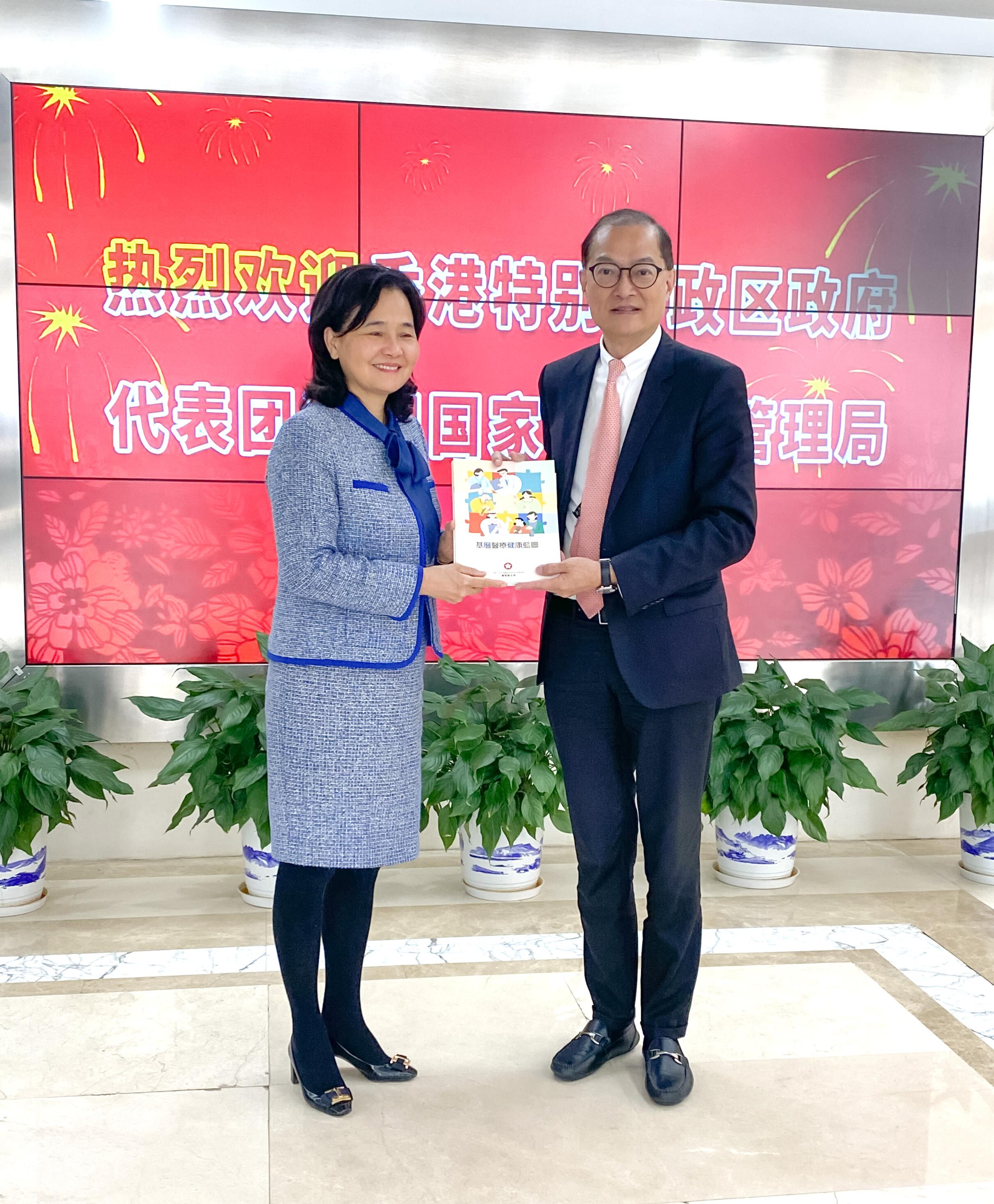 The Secretary for Health, Professor Lo Chung-mau and his delegation called on the National Administration of Traditional Chinese Medicine (NATCM) today (March 16). Photo shows Professor Lo (right) presenting the Primary Healthcare Blueprint released last year to the Party Secretary and Vice Commissioner of the NATCM, Professor Yu Yanhong (left).