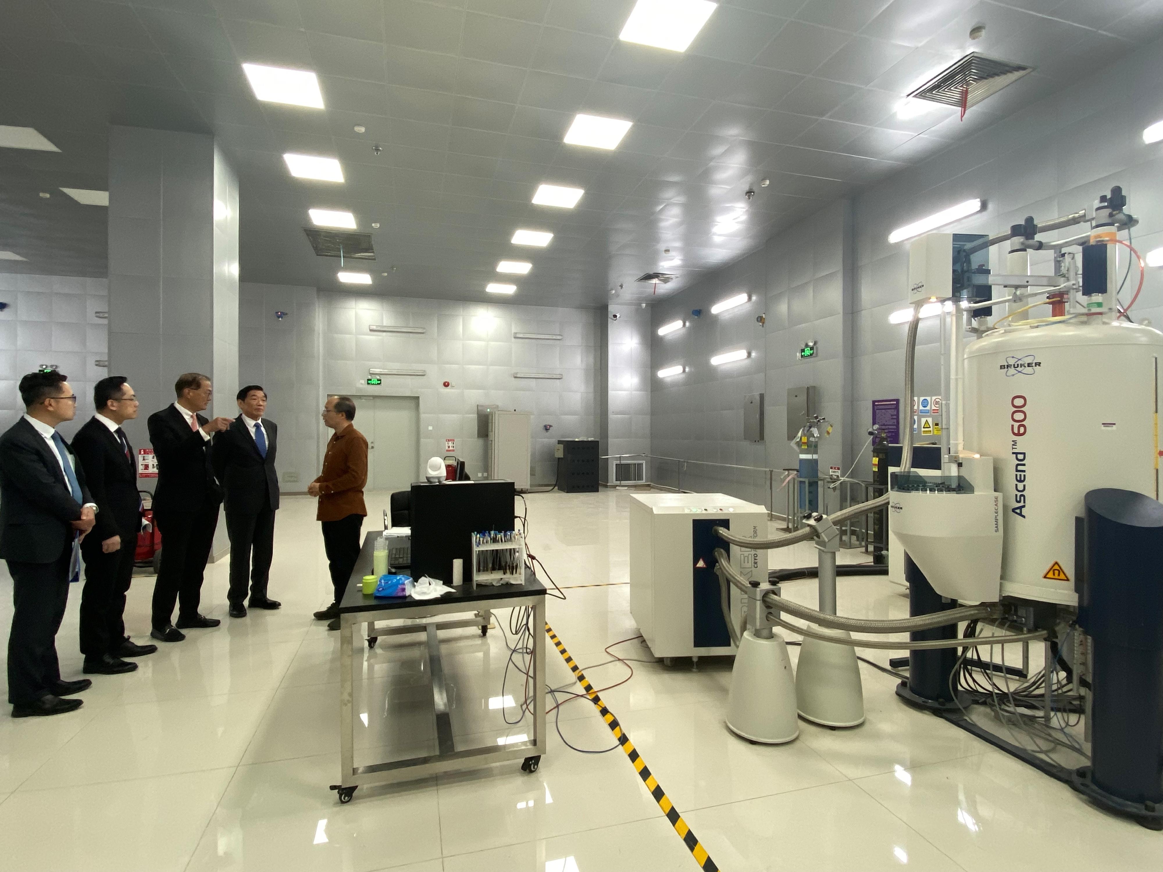 The Secretary for Health, Professor Lo Chung-mau, and his delegation visited the Technology Center for Protein Sciences at Tsinghua University today (March 17). Photo shows Professor Lo (third left); the Director of Health, Dr Ronald Lam (second left); Deputy Secretary for Health Mr Eddie Lee (first left); and the Chairman of the Hospital Authority, Mr Henry Fan (fourth left), learning from the staff about the operation of the laboratory in the Technology Center.