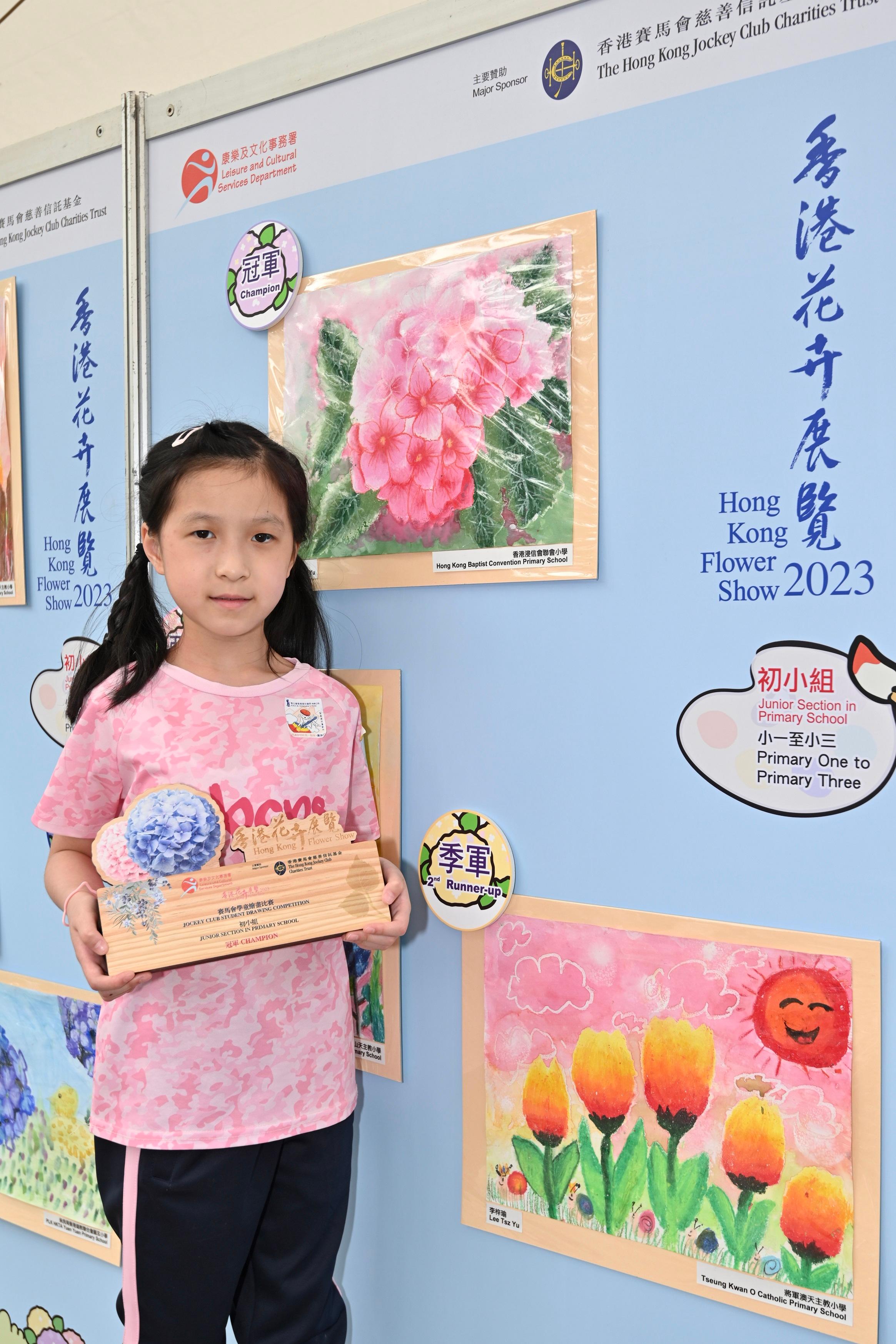 現於維多利亞公園舉行的香港花卉展覽明日（三月十九日）晚上九時閉幕。大會在展覽期間安排了多項文娛活動，當中的賽馬會學童繪畫比賽今日（三月十八日）舉行頒獎典禮，場內同時展出得獎作品。圖示初小組冠軍陳詩予及其得獎作品。