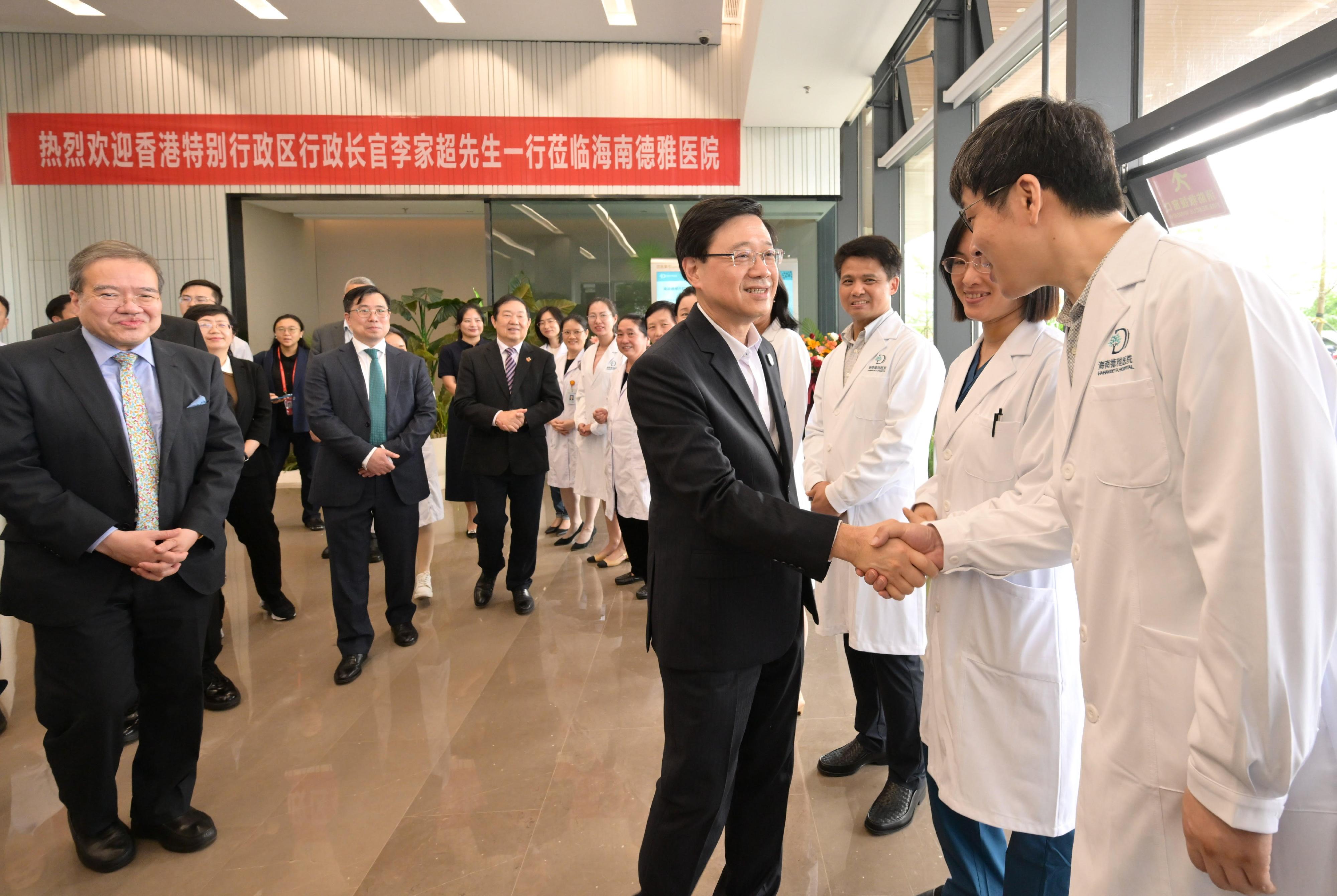 行政長官李家超今日（三月二十九日）在海南到訪博鰲樂城國際醫療旅遊先行區。圖示李家超（右三）與醫院工作人員握手。