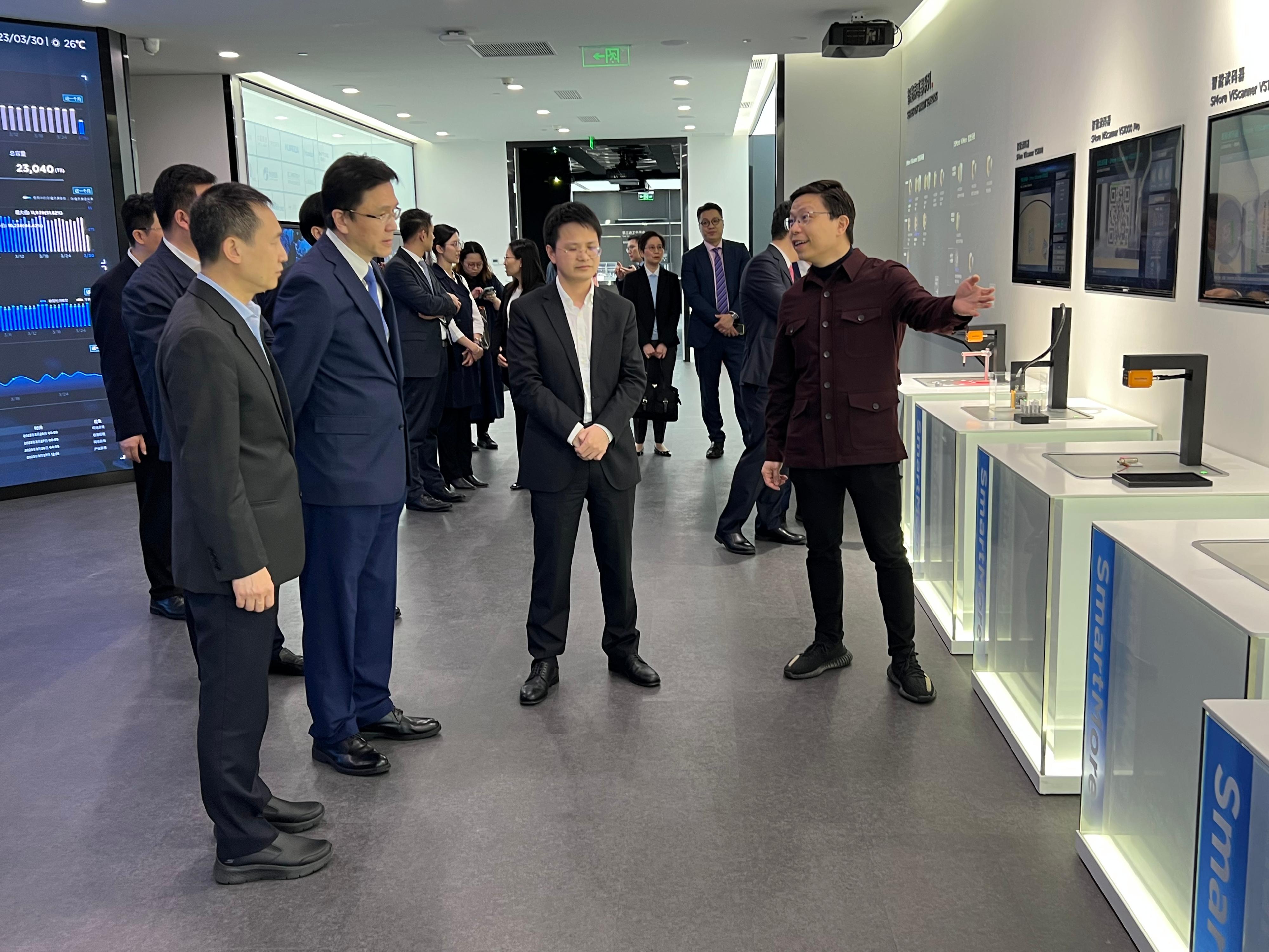 The Secretary for Innovation, Technology and Industry, Professor Sun Dong (second left), visits SmartMore Corporation in Qianhai today (March 30). Looking on is Member of the Standing Committee of the Shenzhen Municipal Committee of the Chinese Communist Party Mr Zeng Pai (first left).