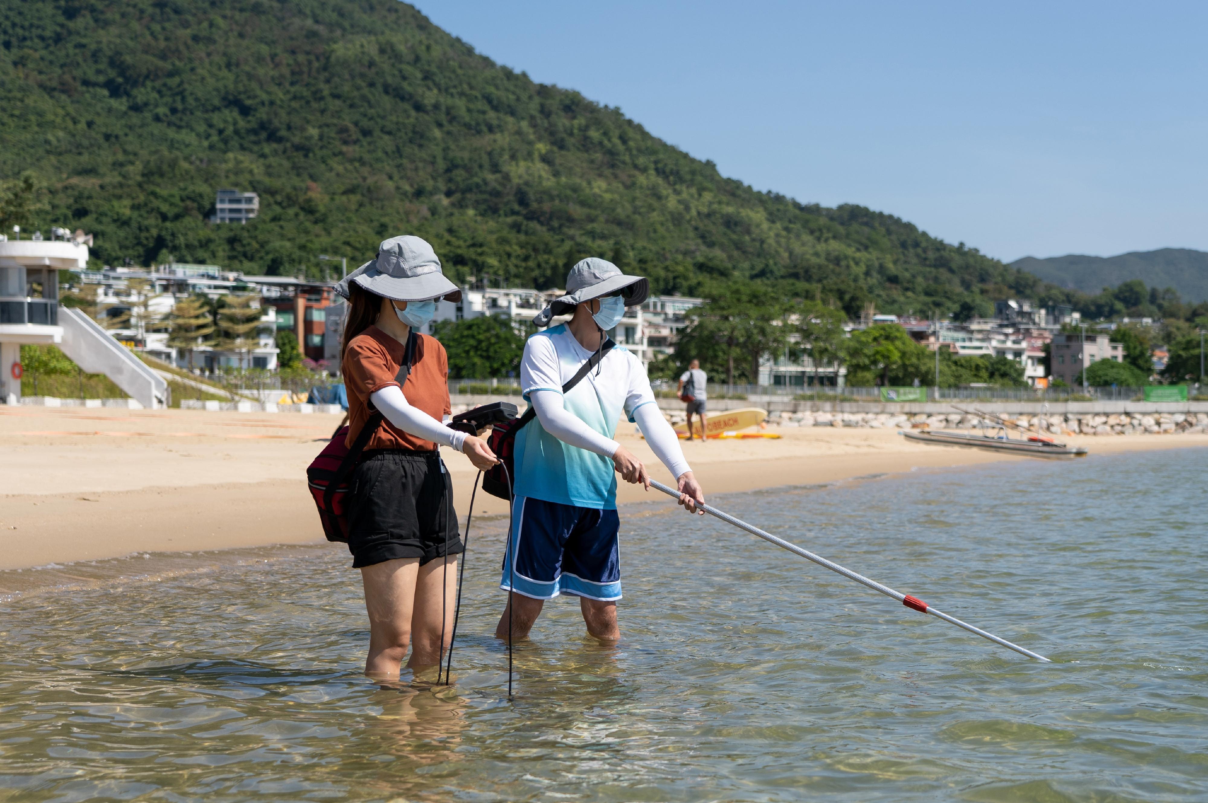 The 2022 report on beach water quality shows that all Hong Kong gazetted beaches have fully met the bacteriological Water Quality Objective for 13 consecutive years. Picture shows staff of the Environmental Protection Department conducting on-site water sampling and measuring field data.